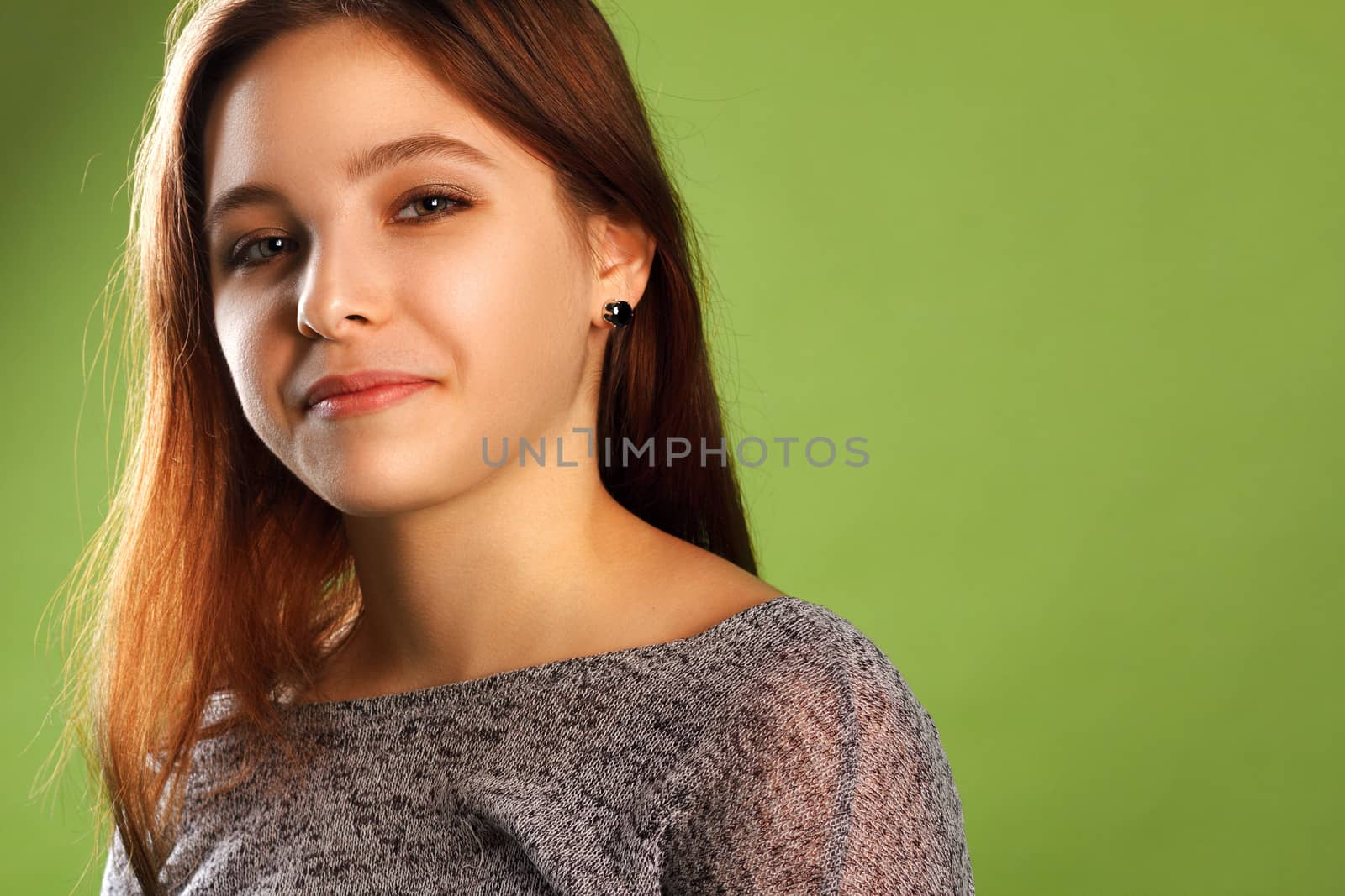 Portrait of young smiling girl on green