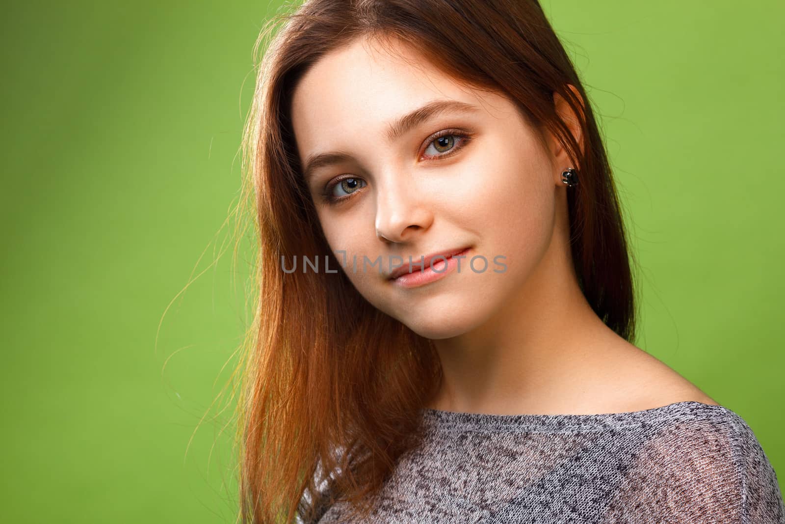 Portrait of young smiling girl on green