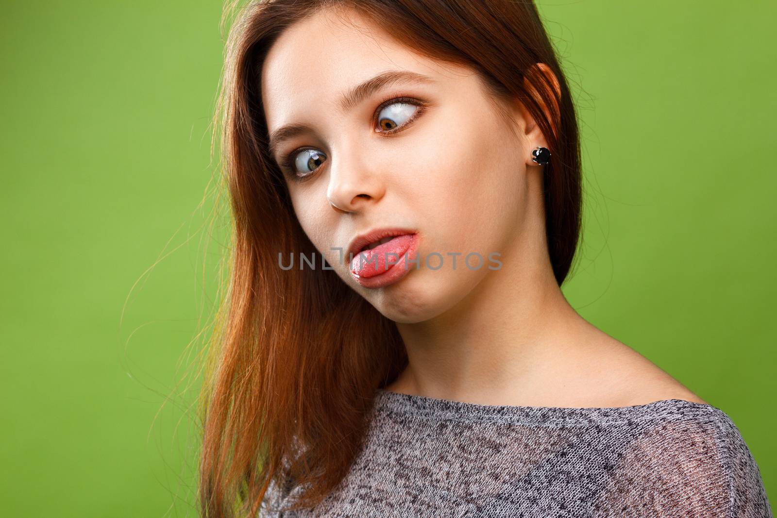 Girl shows tongue and ape on green