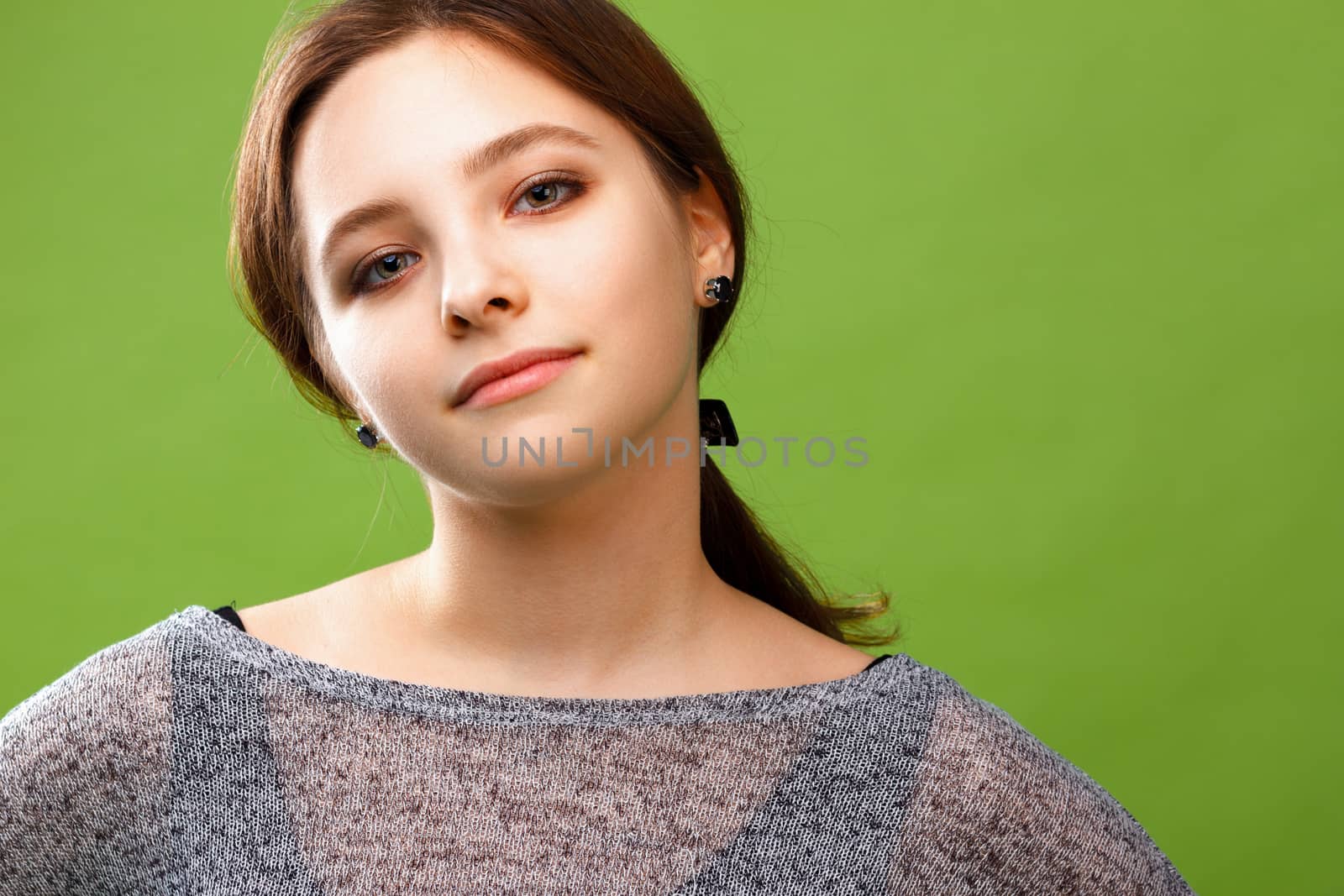 Portrait of young smiling girl on green