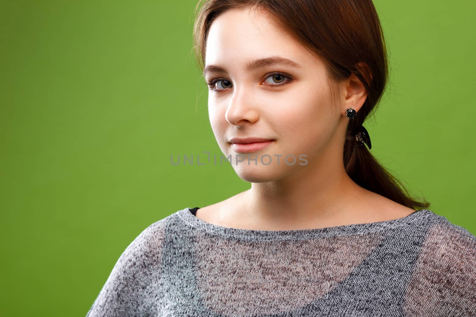 Portrait of young smiling girl on green