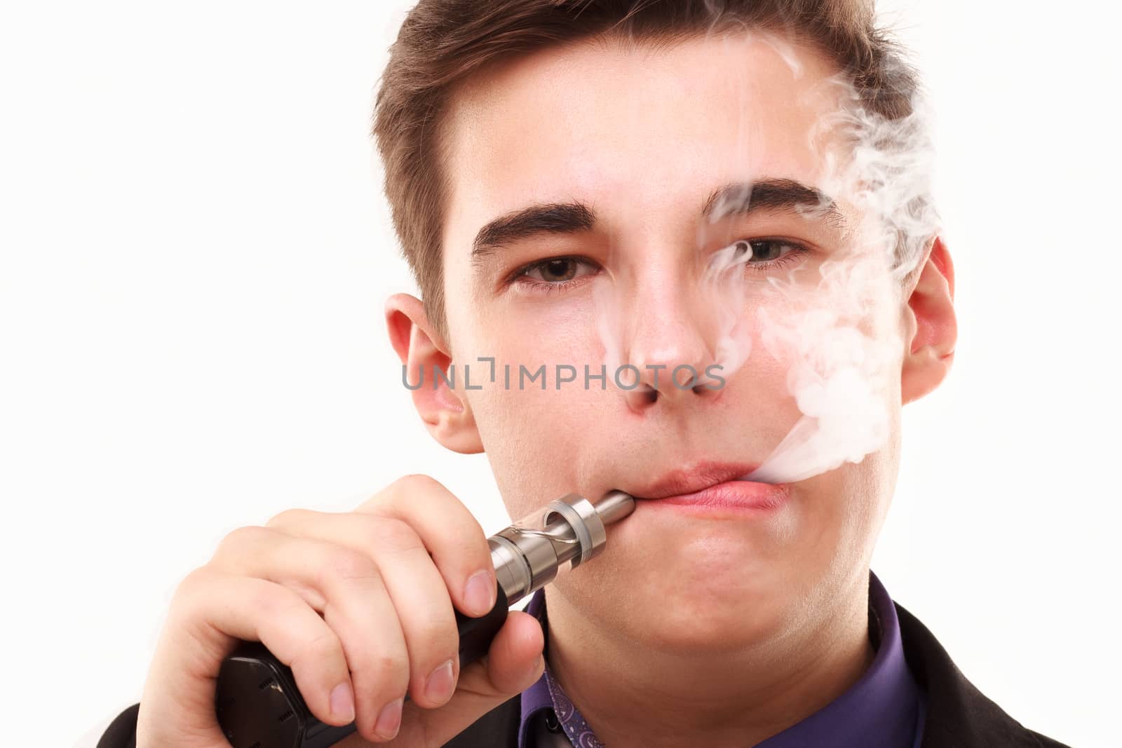 Portrait of a man in suit smoking an e-cigarette isolated on white. Let the steam out of his mouth