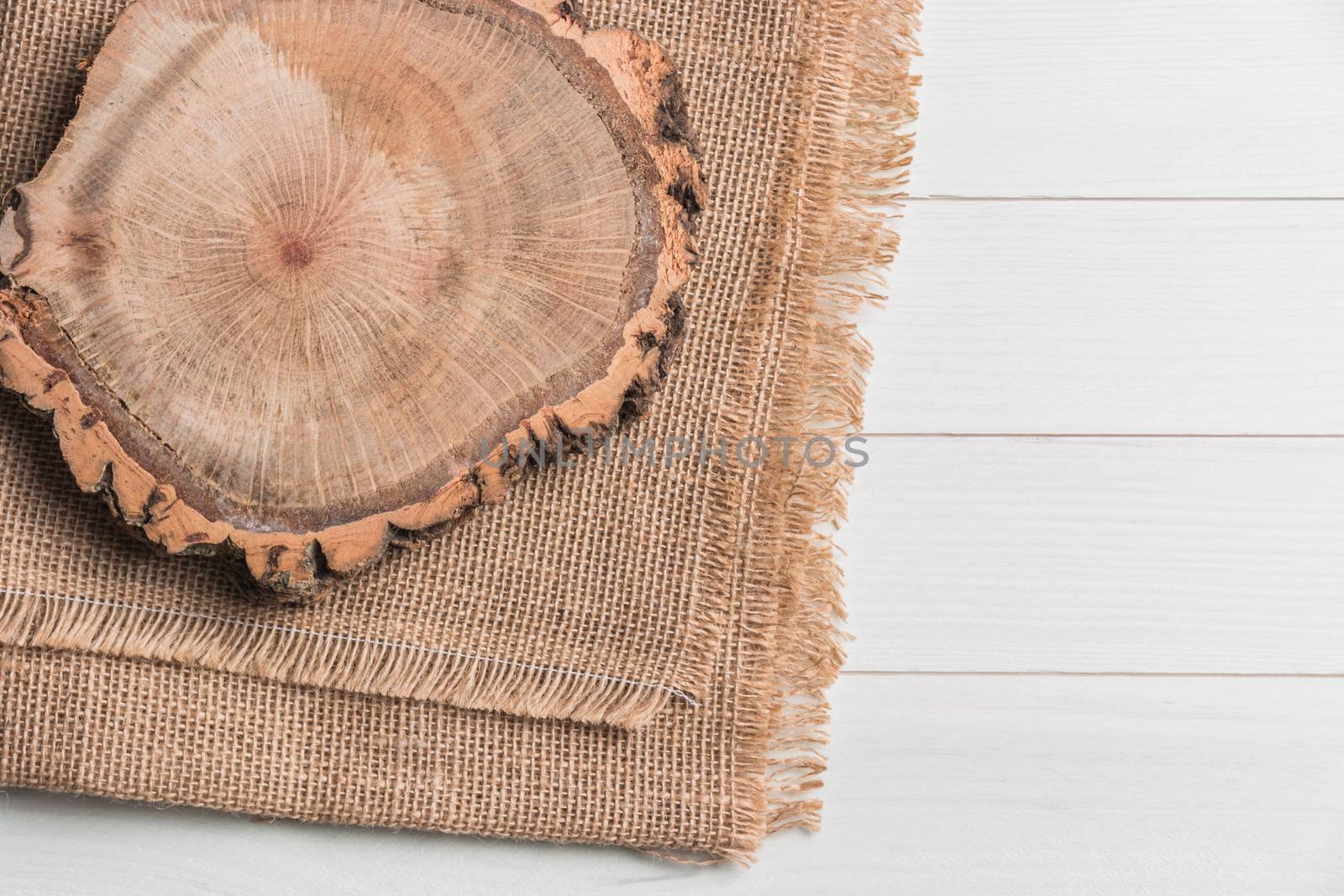 Wood plank board above burlap on wooden table, useful as a background. Top view with copy space.