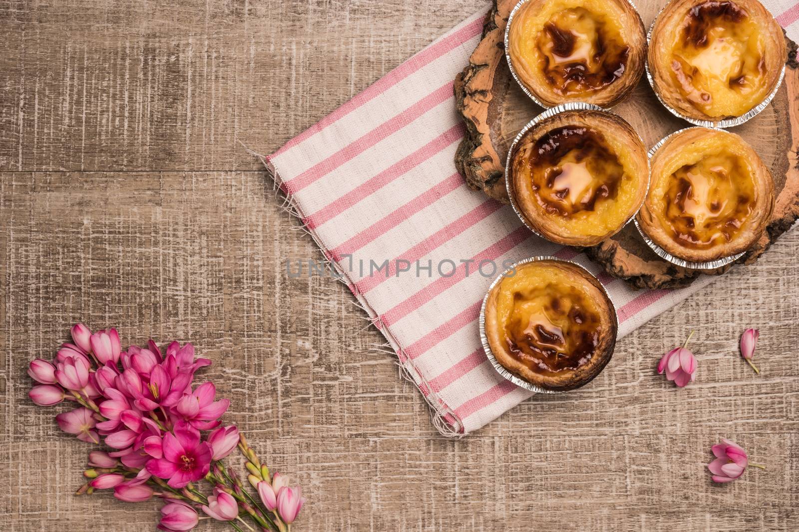 Pasteis de nata, typical Portuguese egg tart pastries on a set table. Top view with copy space