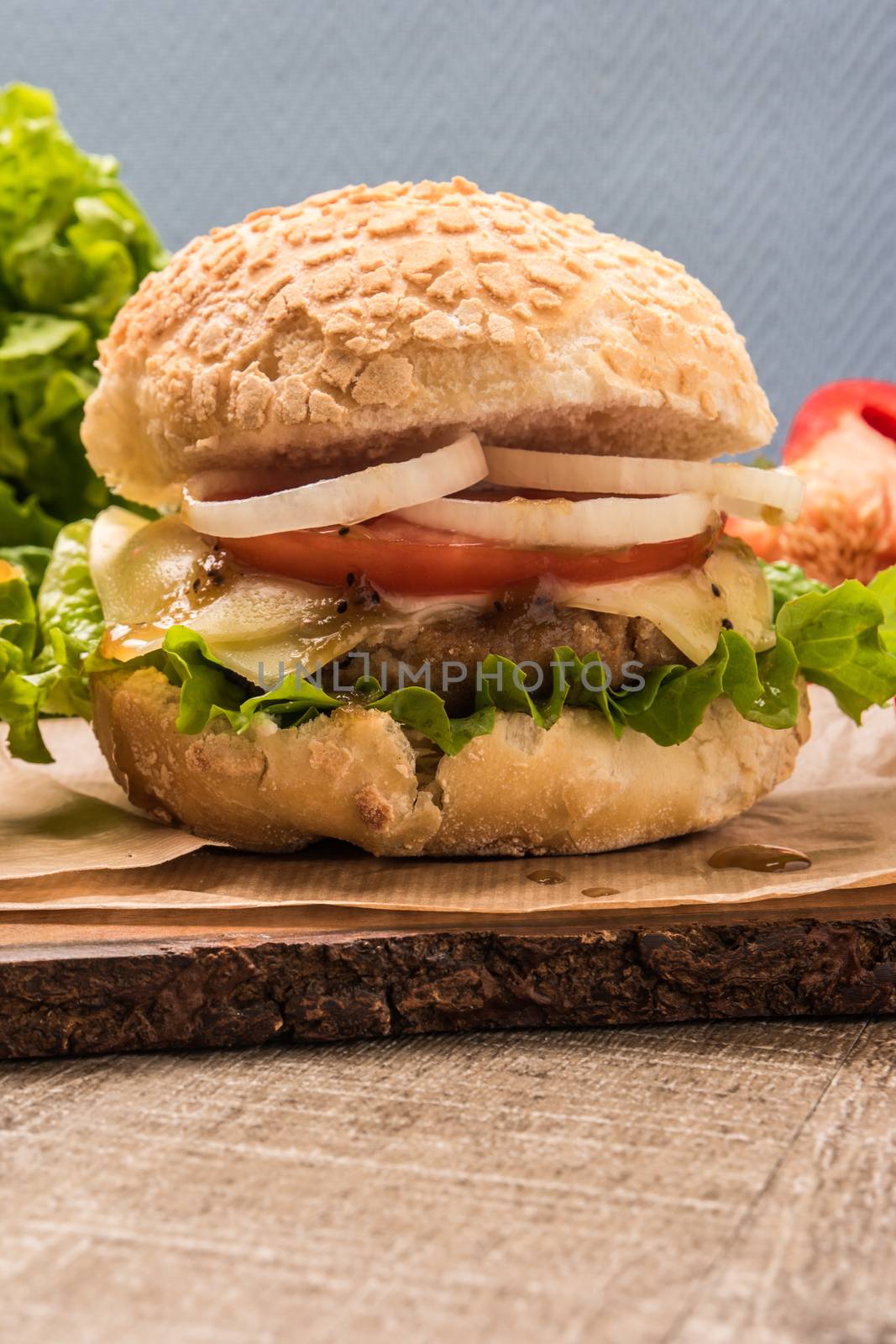 Homemade vegetarian burgers with fresh organic vegetables on rustic wooden background