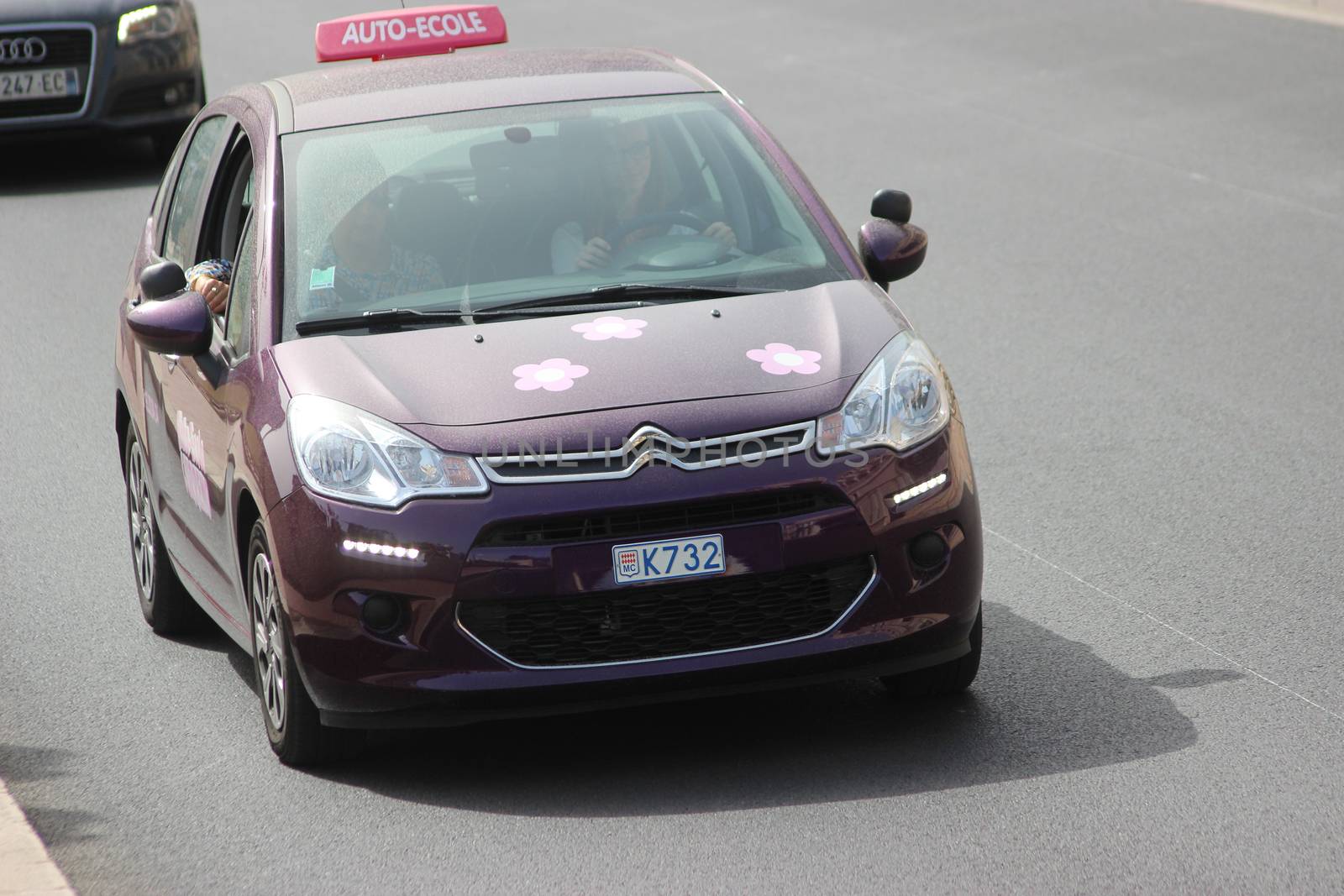 Monte-Carlo, Monaco - April 6, 2016: Purple Citroen C3 Instructional Vehicle on Avenue d'Ostende in Monaco. Woman Driving a French Car Citroen C3 in the South of France