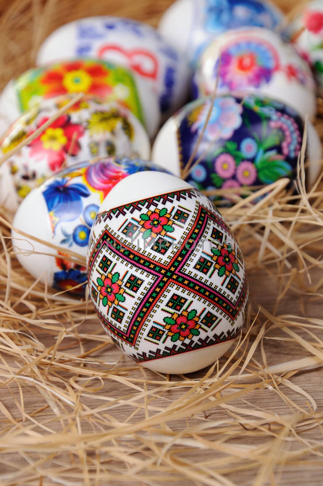 A variety of painted Easter eggs on the table in the hay