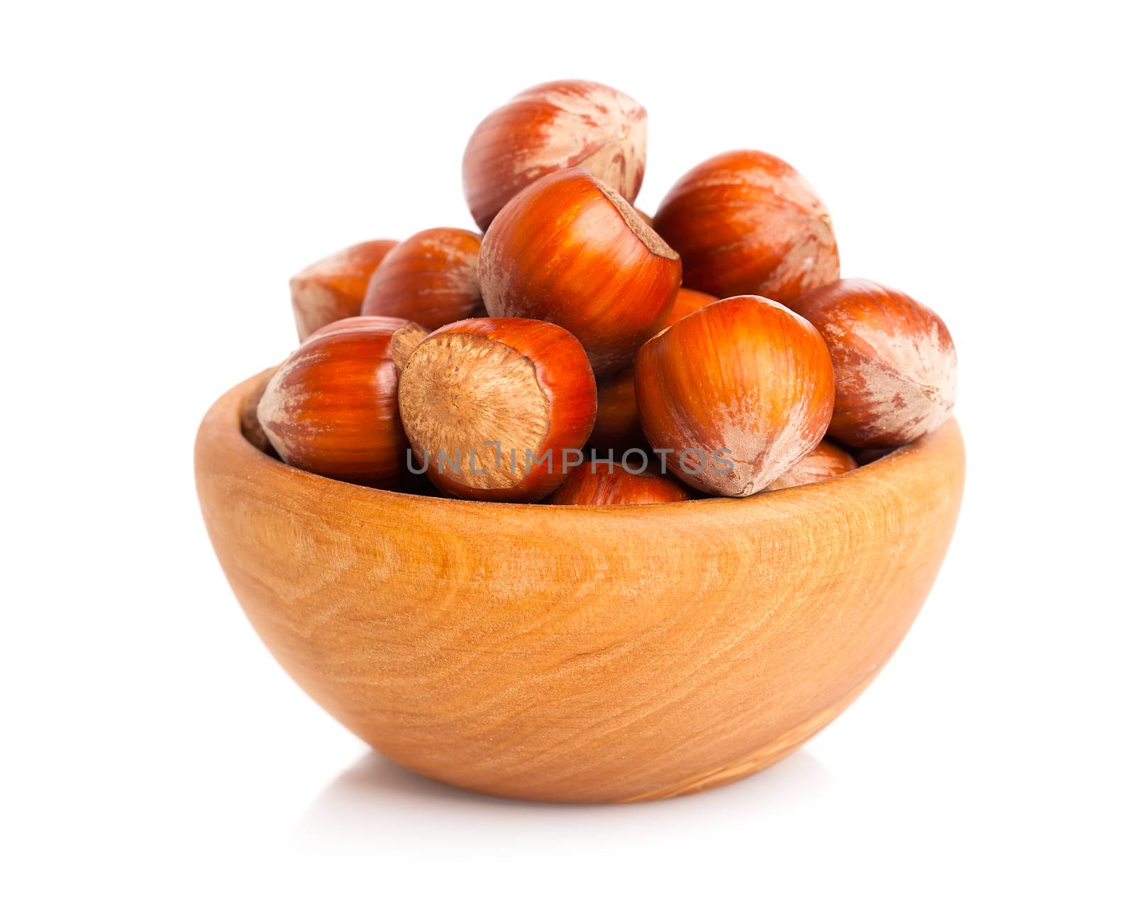 Hazelnuts in a wooden bowl on white background by motorolka