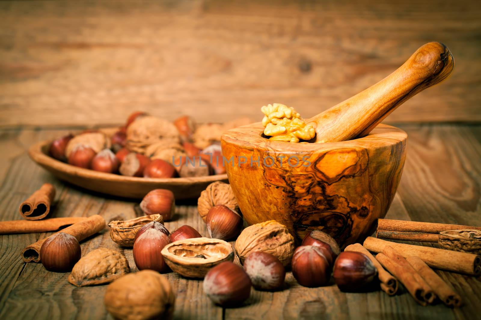 Hazelnuts in a wooden bowl on rustic background by motorolka
