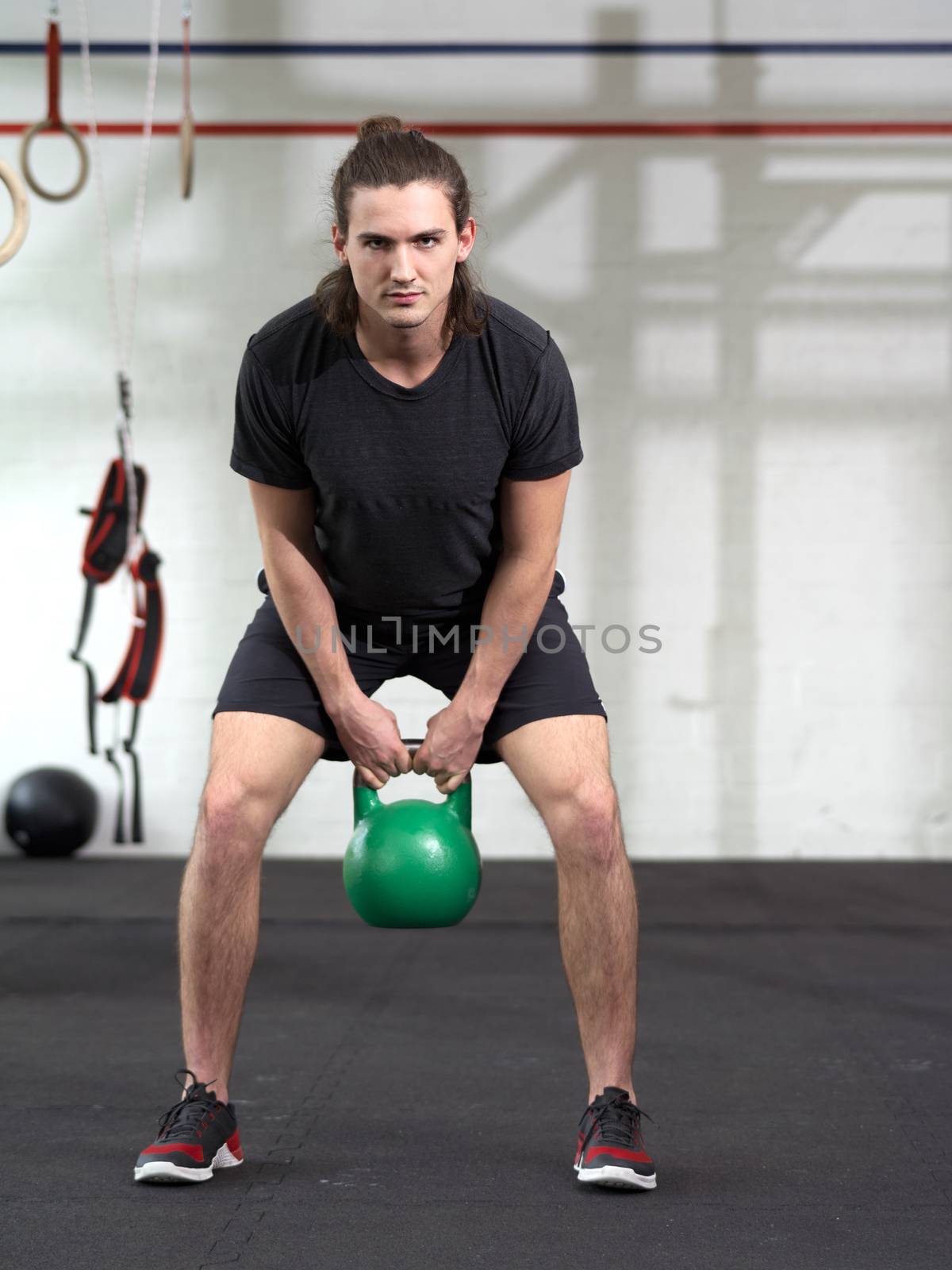 Young man exercising with kettlebell by sumners