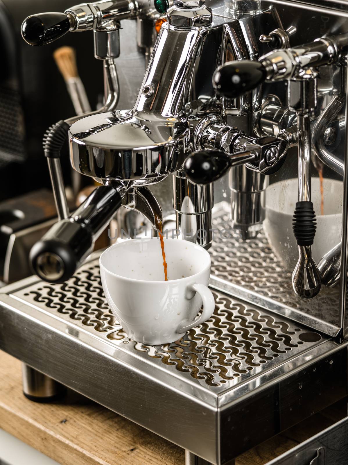 Photo of an espresso being made with a professional coffee machine.
