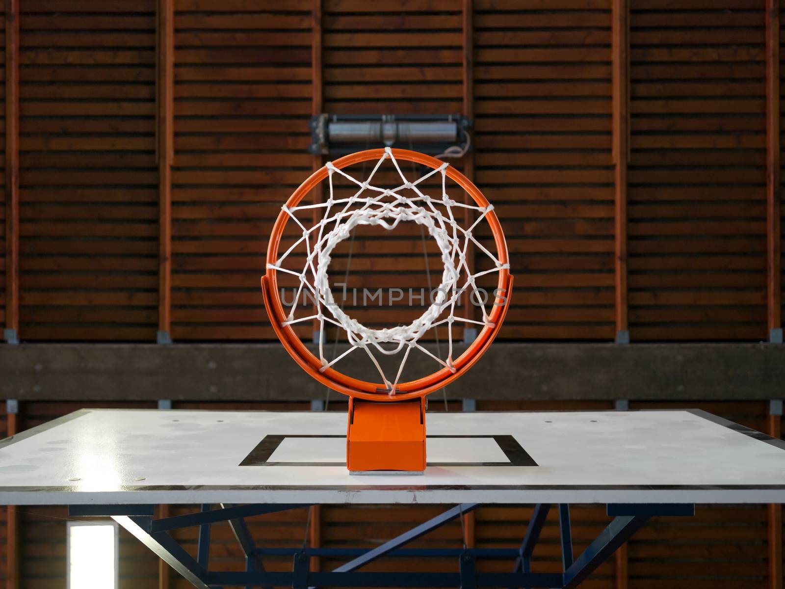 Photo of an indoor basketball hoop from below.
