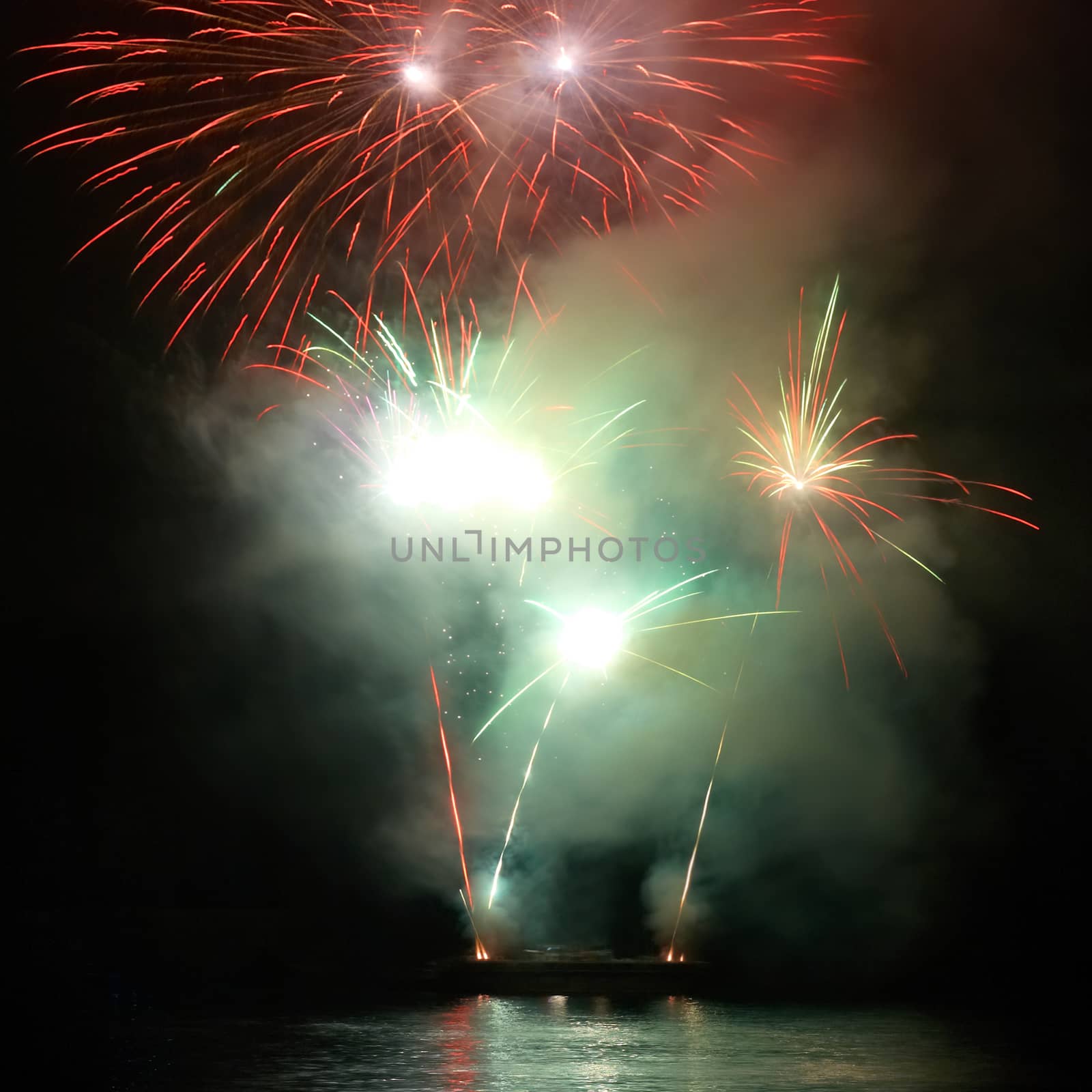 Green colorful fireworks on the black sky background. Holiday celebration.