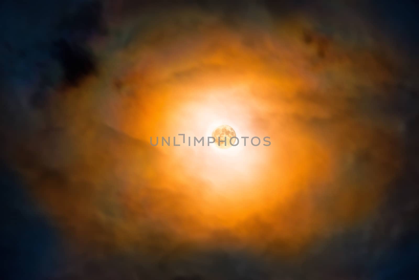 Night view at the full moon through moving orange clouds. Abstract scene