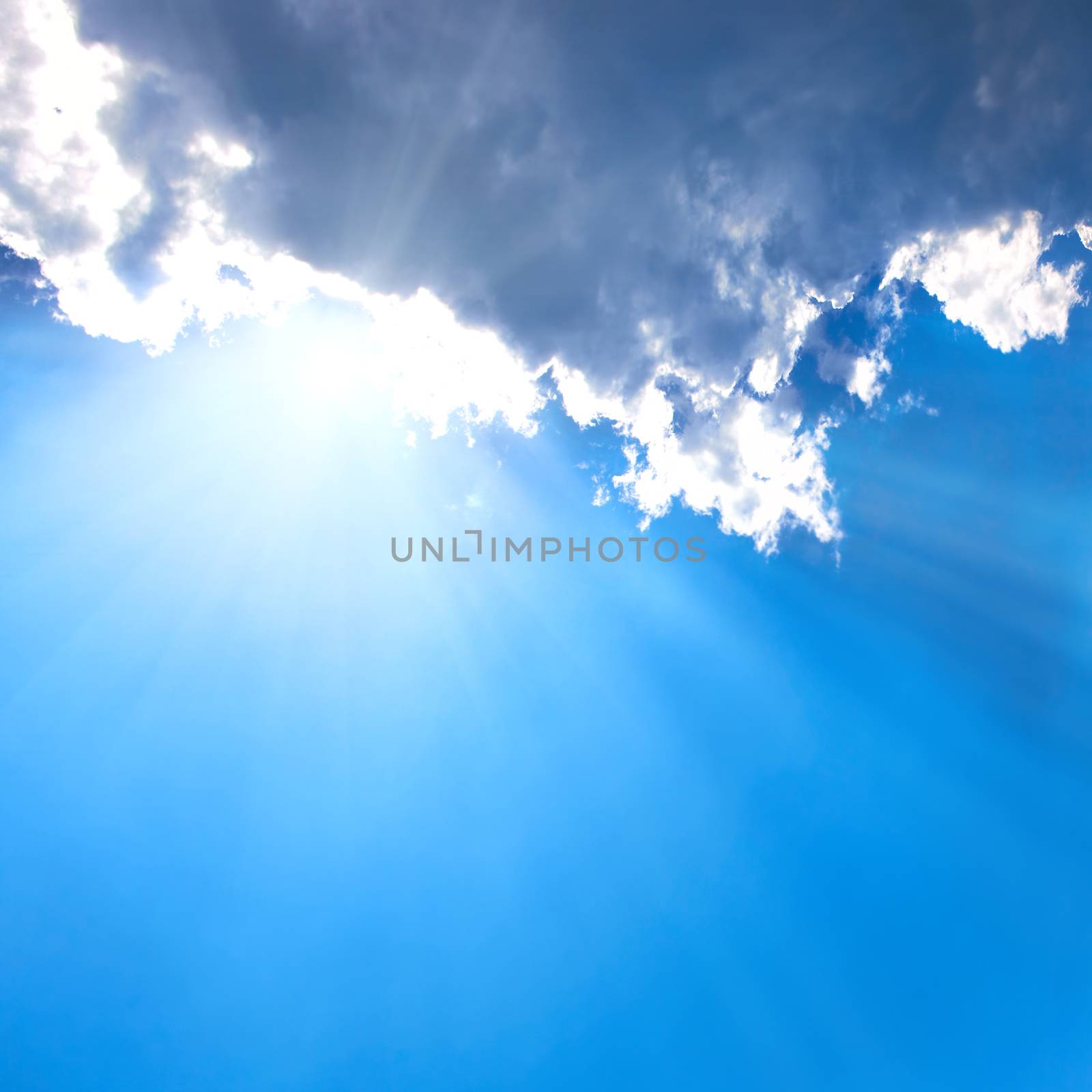 Beautiful blue sky with sunbeams and clouds. Sun rays.