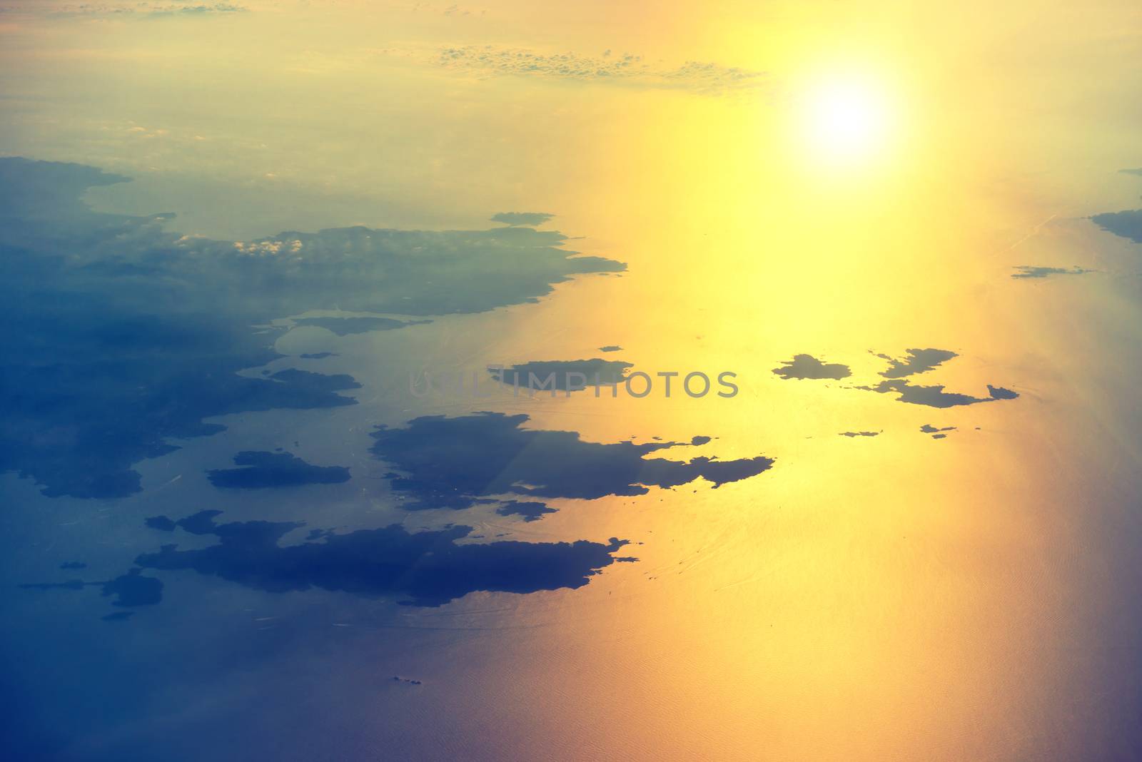 View from a plane to sunset on the sky. Fluffy clouds background