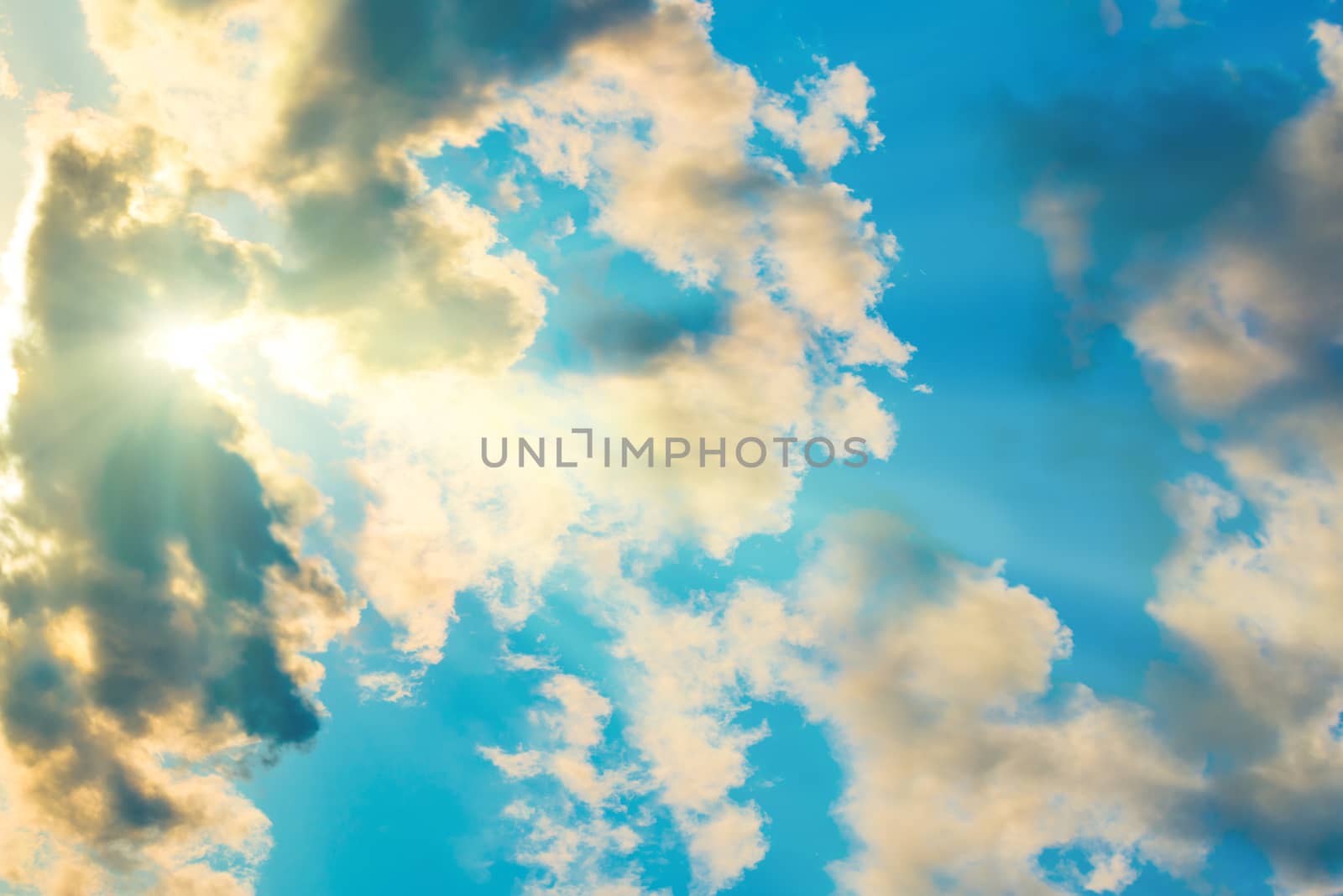 Blue clouds and sky. Natural background with sunbeams