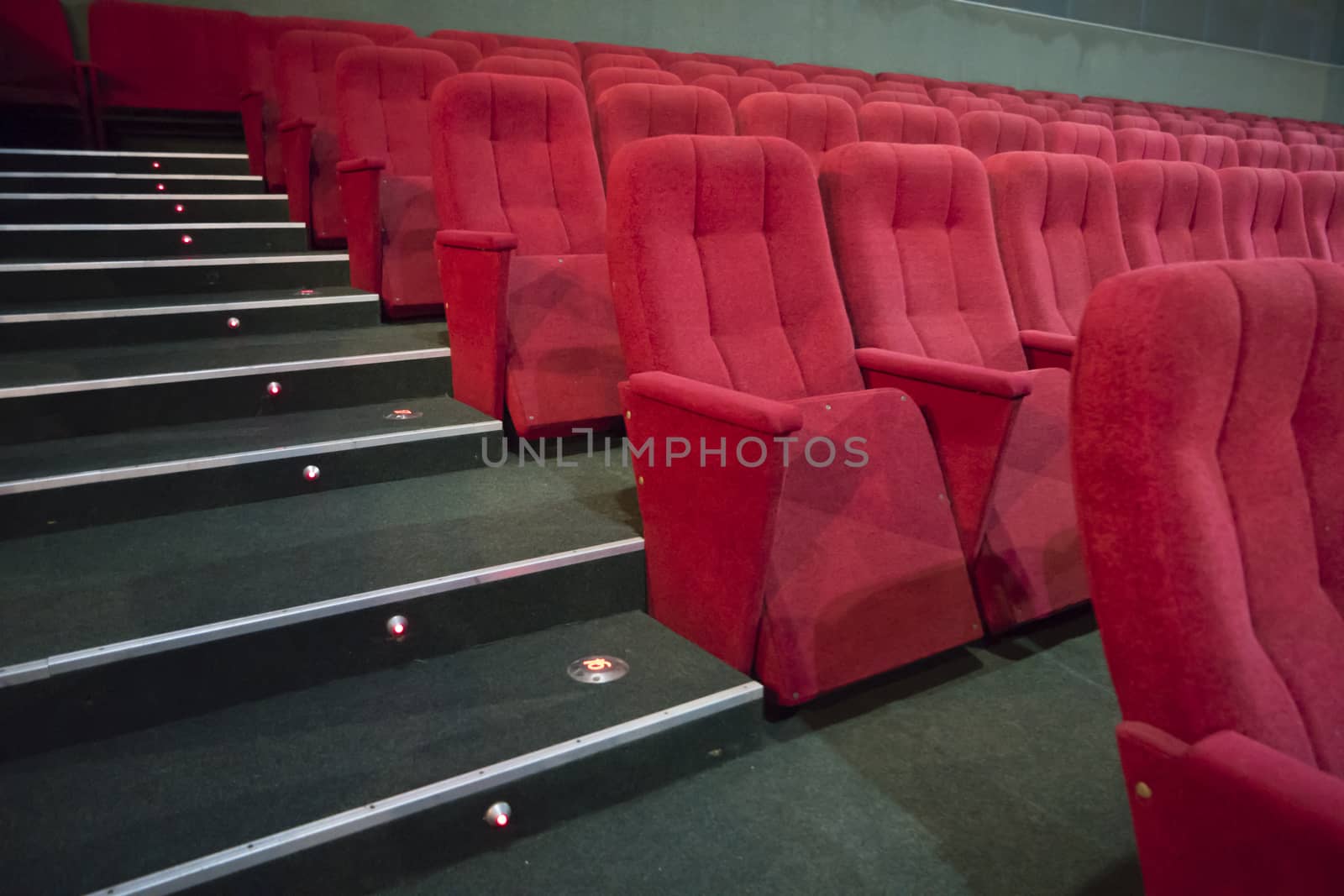 Aisle with rows of red seats in the modern theater