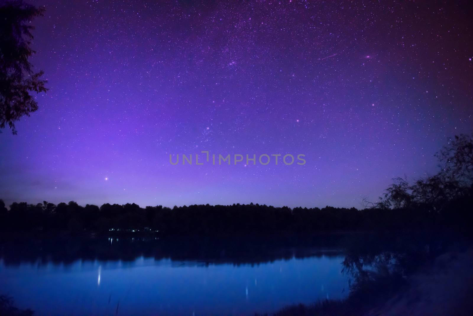 Beautiful night sky with many stars on a lake by vapi