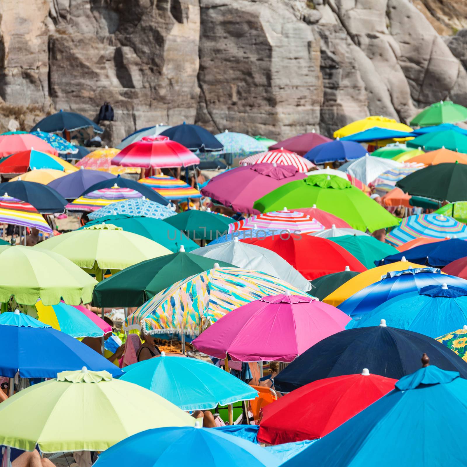 Many colorful umbrellas on the sandy beach.