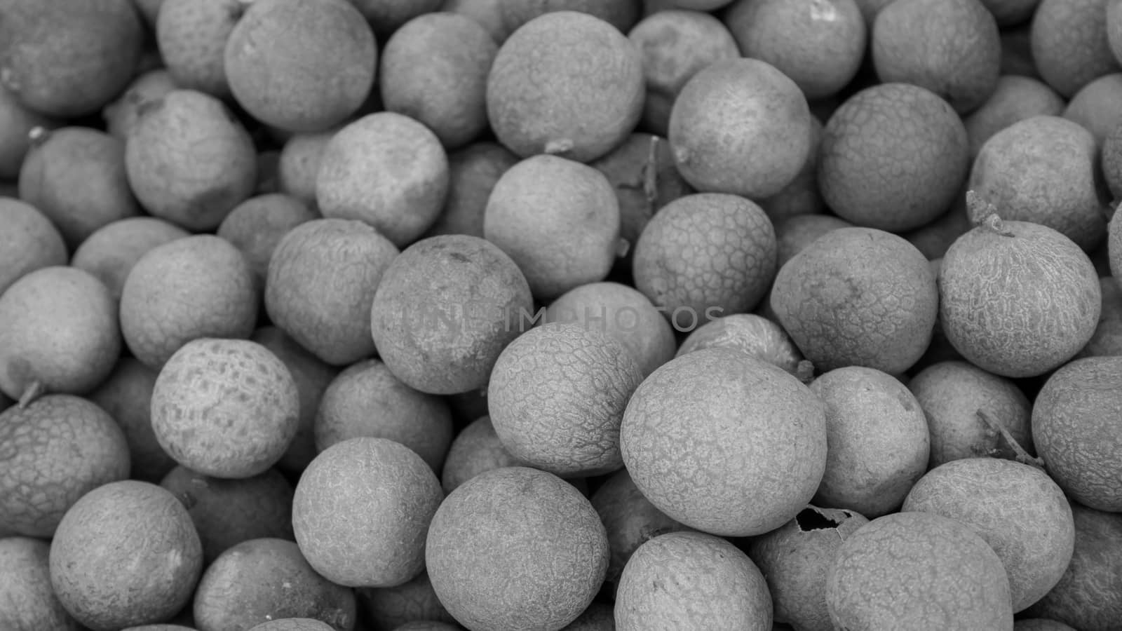 The close up of group of fresh longan at fruit market. (black and white tone)