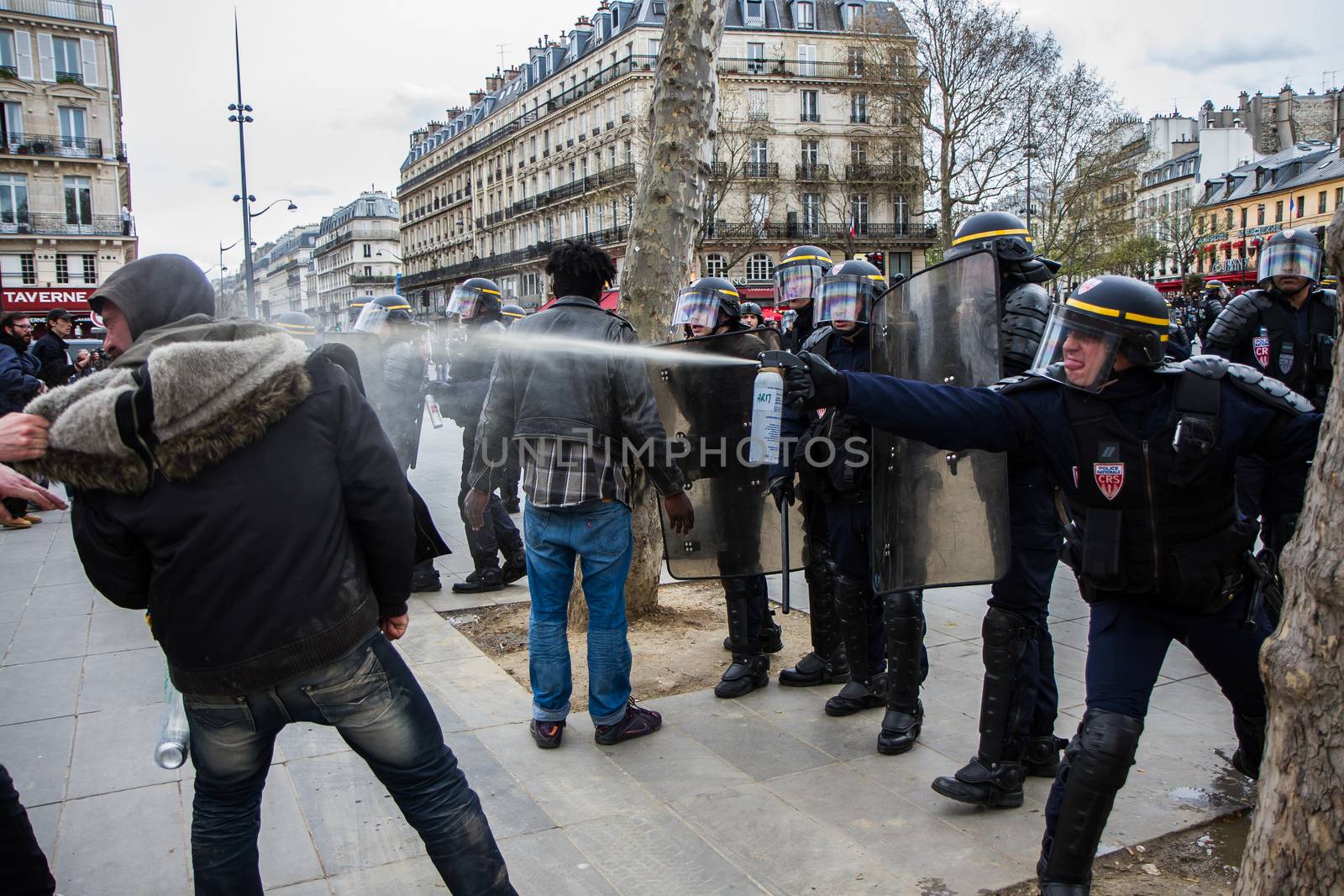 FRANCE, Paris: A riot policeman throws tear gas at a protester as hundreds demonstrate against the French government's proposed labour law reforms on April 14, 2016 in Paris. Fresh strikes by unions and students are being held across France against proposed reforms to France's labour laws, heaping pressure on President Francois Hollande who suffered a major defeat over constitutional reforms on March 30.