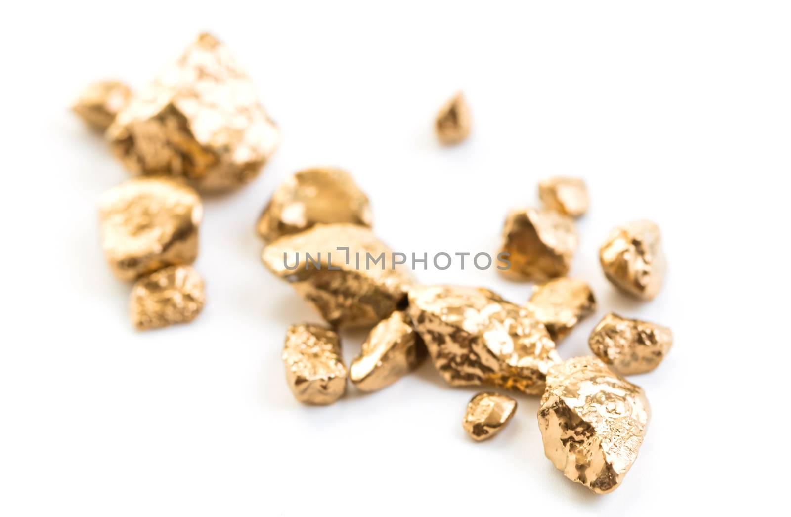 handful of gold nuggets close-up on a white background