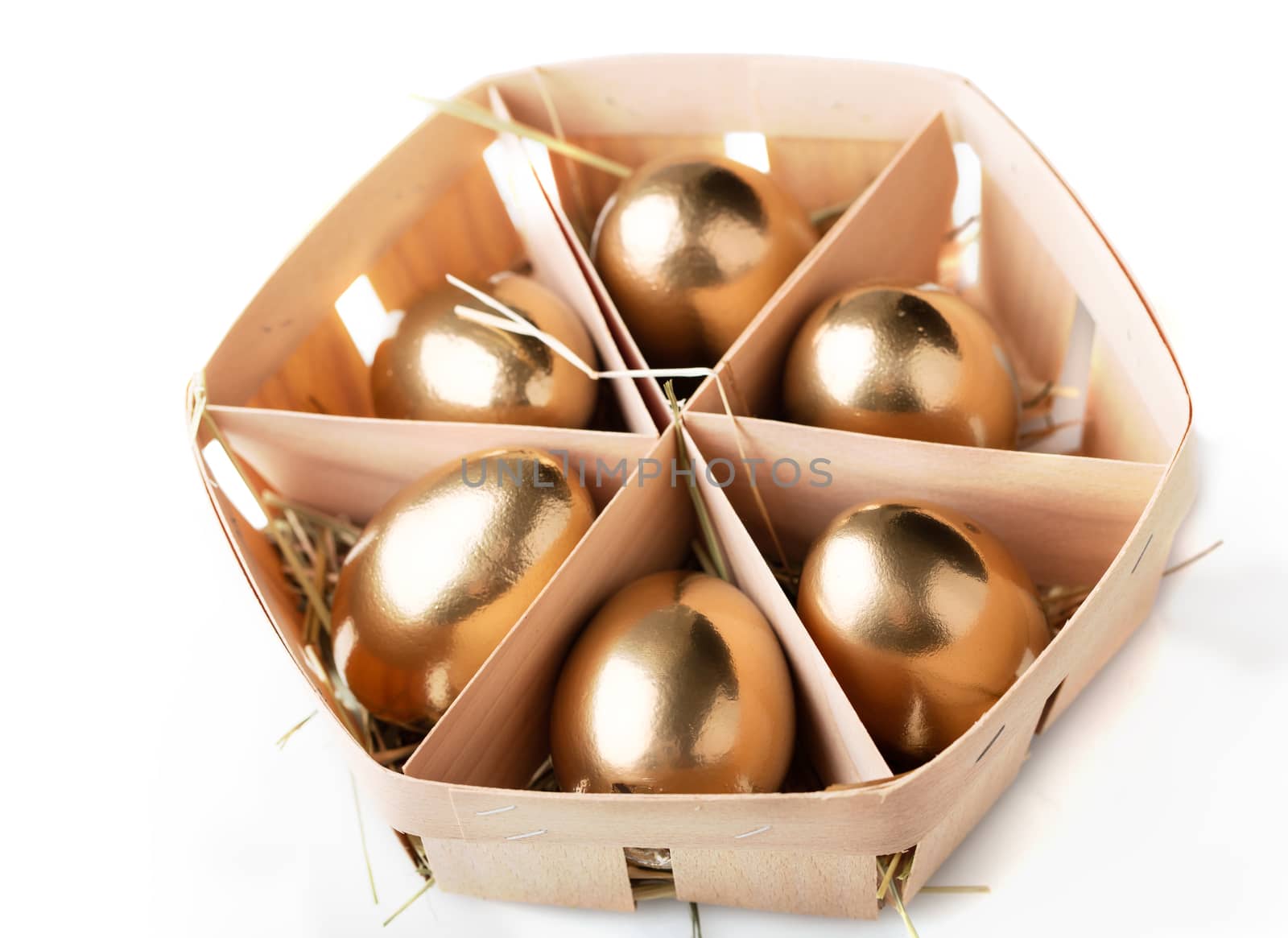 golden eggs in a basket on white background