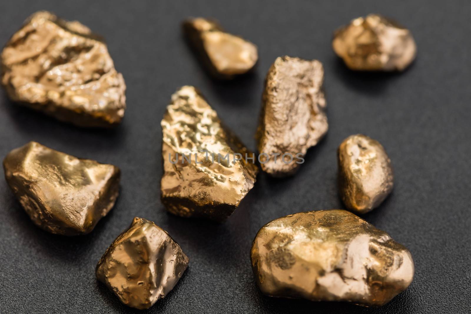 handful of gold nuggets close-up on a black background