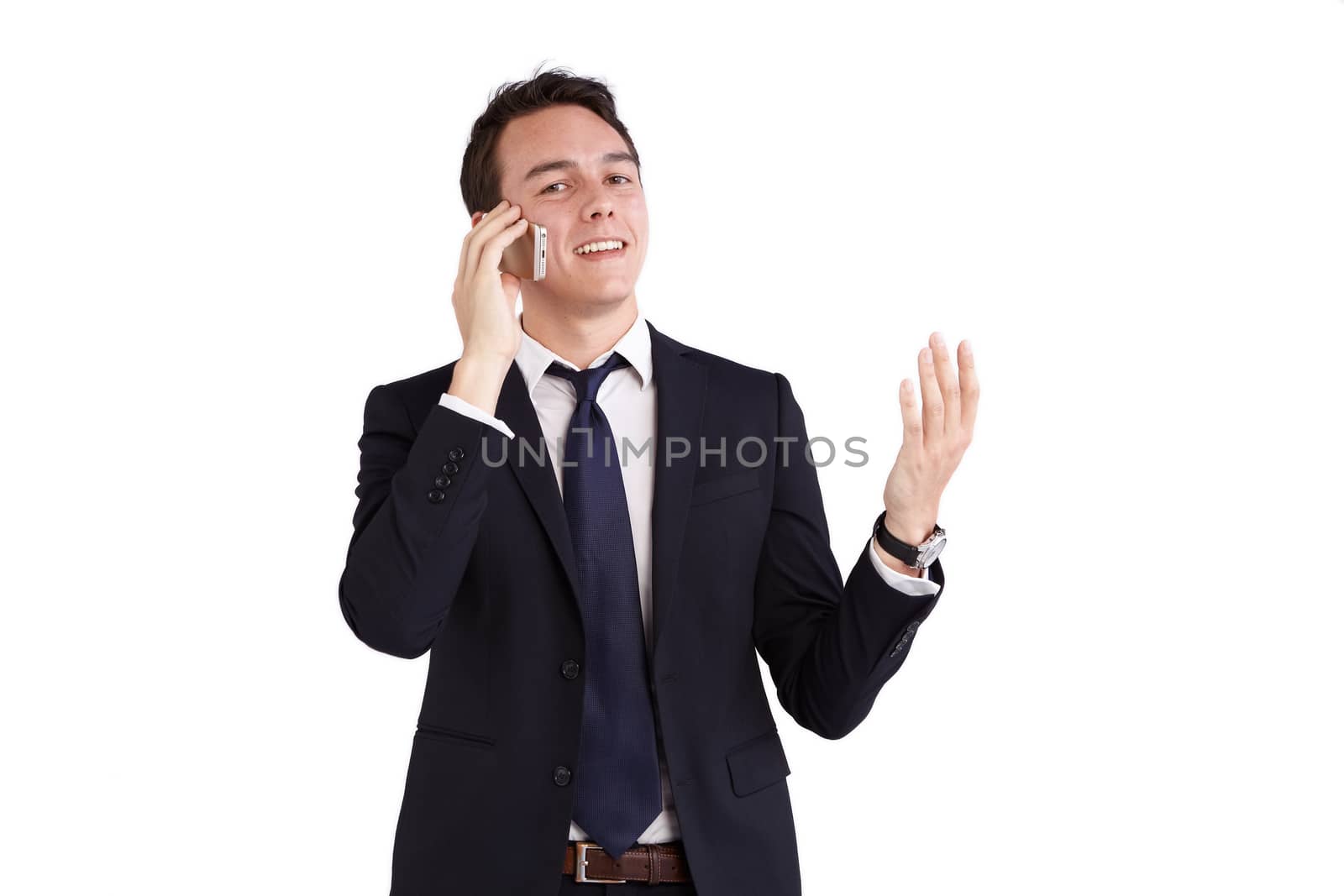 A young caucasian male businessman smiling with raised hand holding a mobile phone looking at camera.