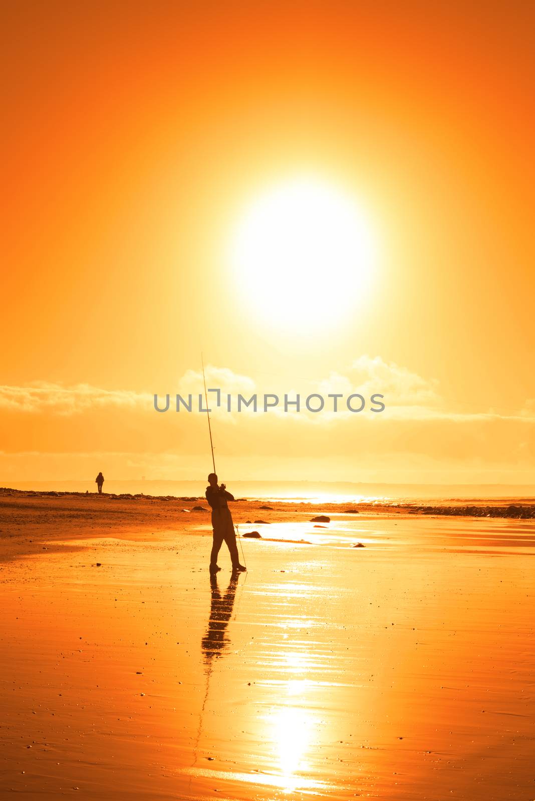 lone fisherman fishing on the Ballybunion beach by morrbyte