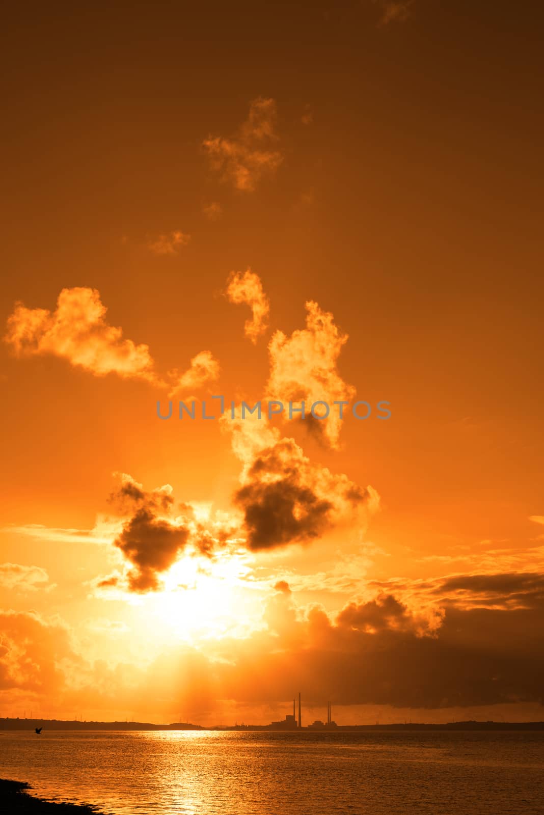 orange sunset over a power station on the river shannon in ireland