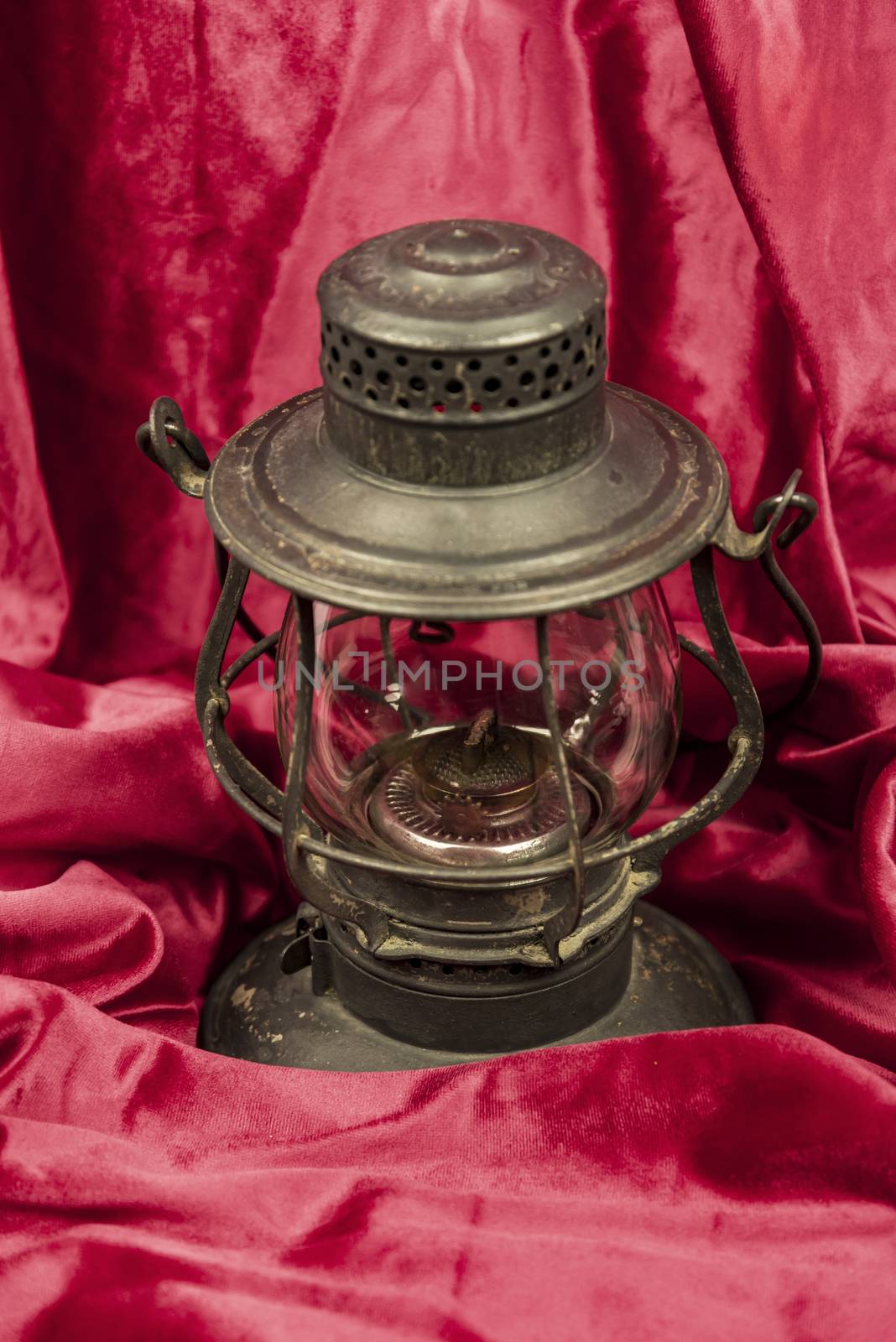 Old oil lantern isolated on red background