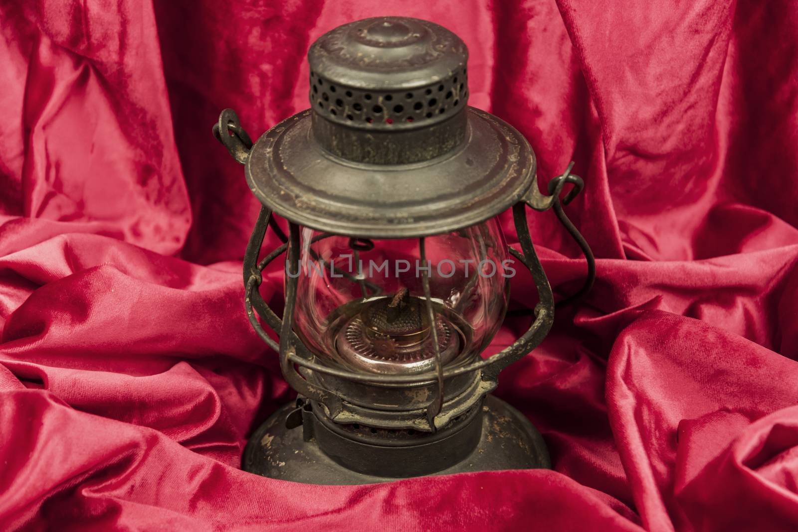 Old oil lantern isolated on red background