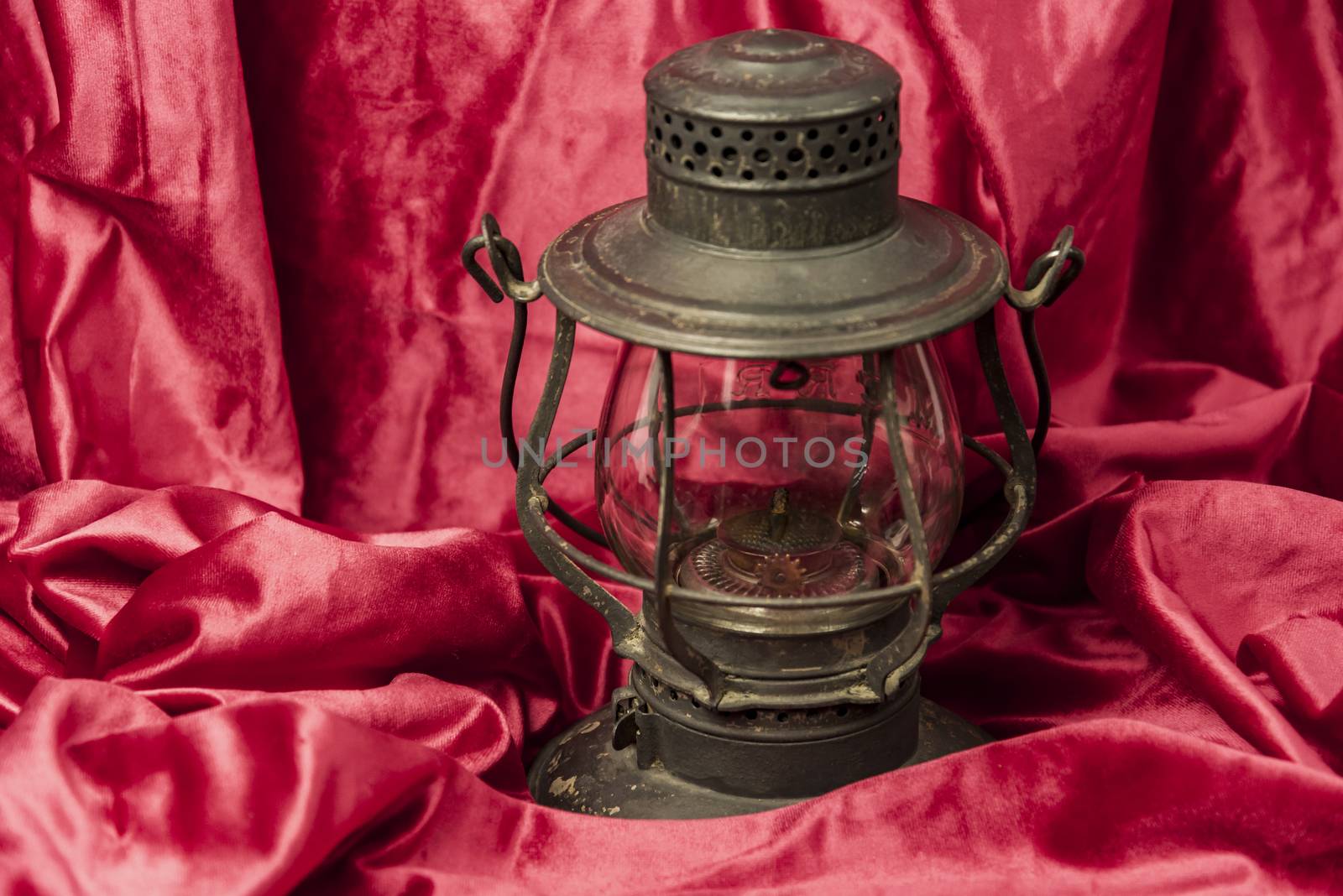 Old oil lantern isolated on red background