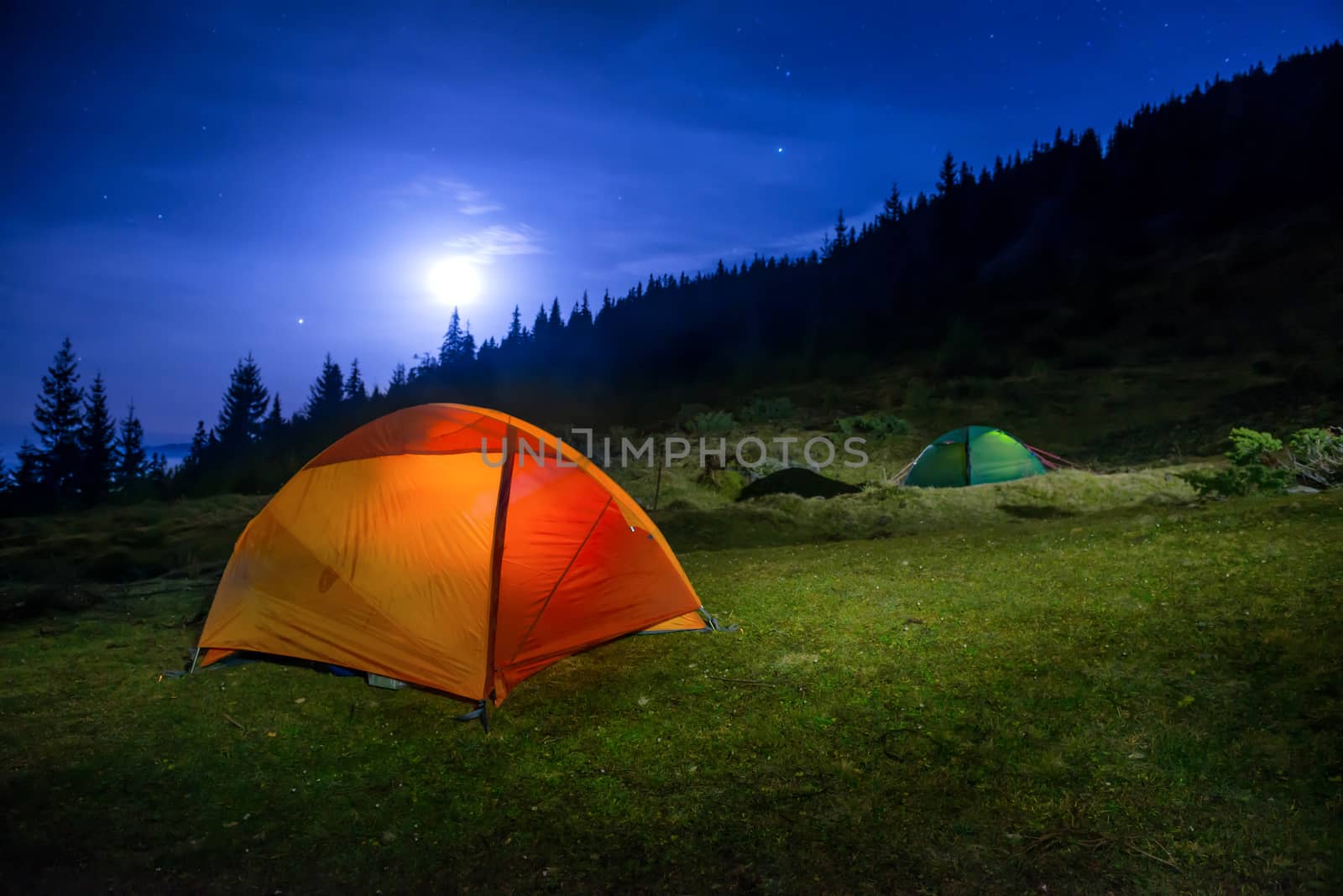 Two Illuminated orange and green camping tents by vapi