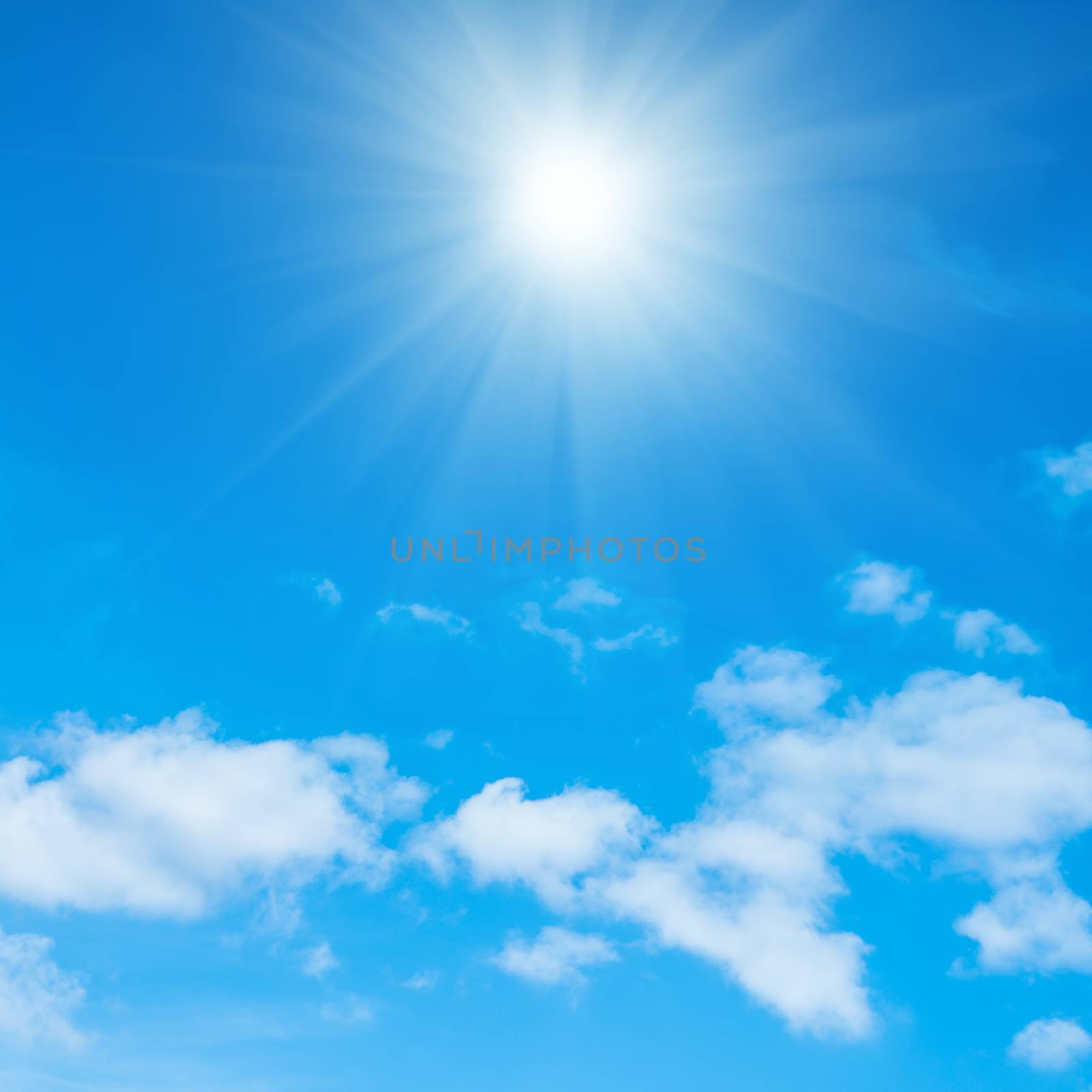 Beautiful blue sky, fluffy white clouds and shining sun with rays