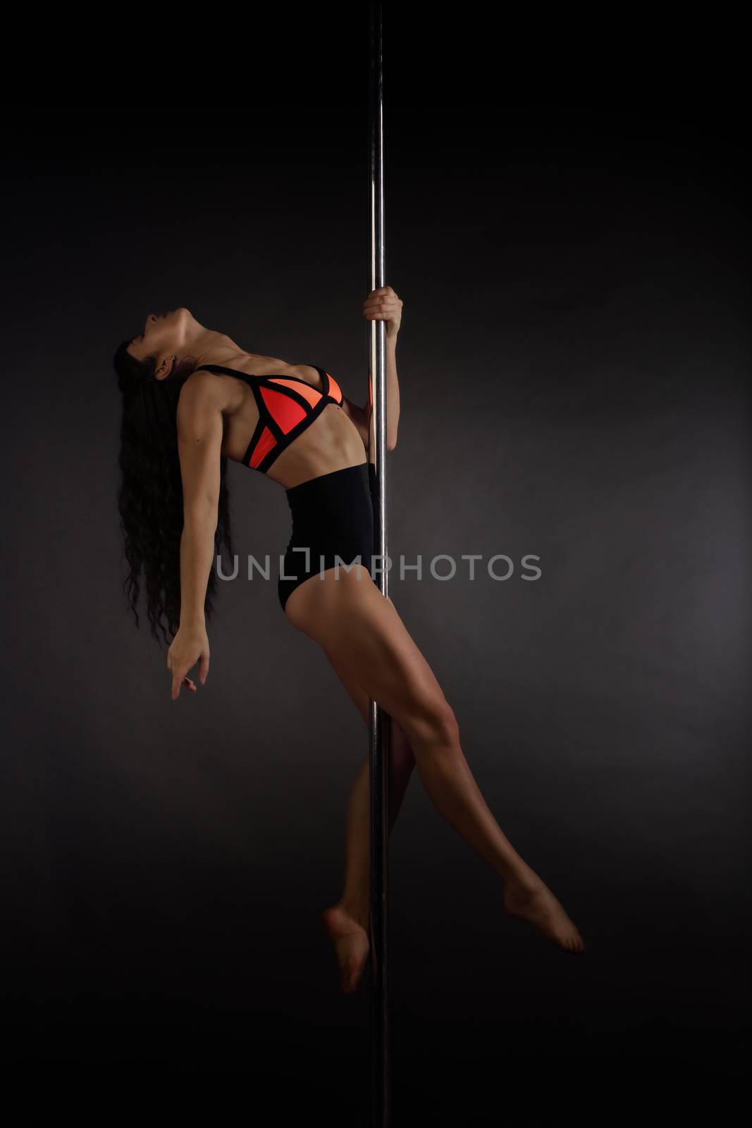 Woman performing pole dance by destillat