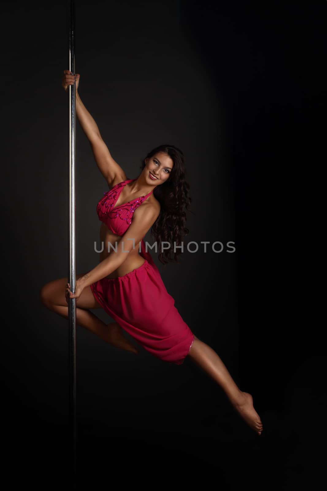 Woman performing pole dance by destillat