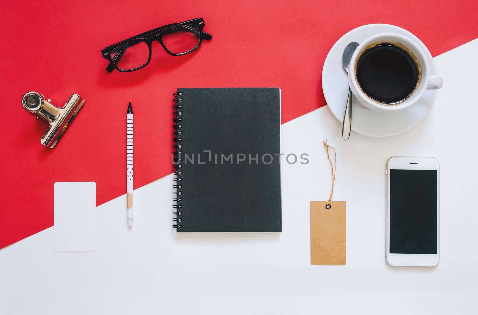 Creative flat lay photo of workspace desk with smartphone, eyeglasses, coffee, tag and notebook with copy space background, minimal styled
