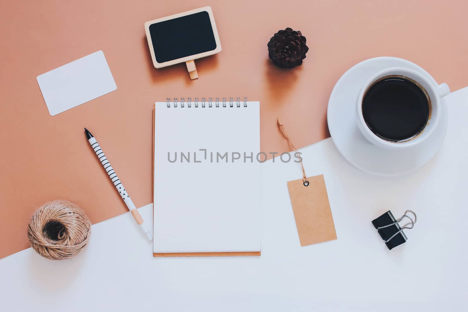 Creative flat lay photo of workspace desk with smartphone, coffee, tag and notebook with copy space background, minimal styled
