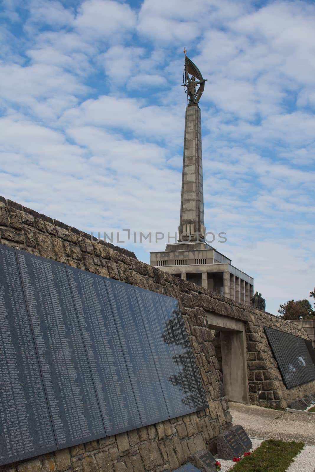 Graveyard of the soldiers liberating Bratislava during the second World War. Column of the Memorial, important landmark. Cloudy sky.