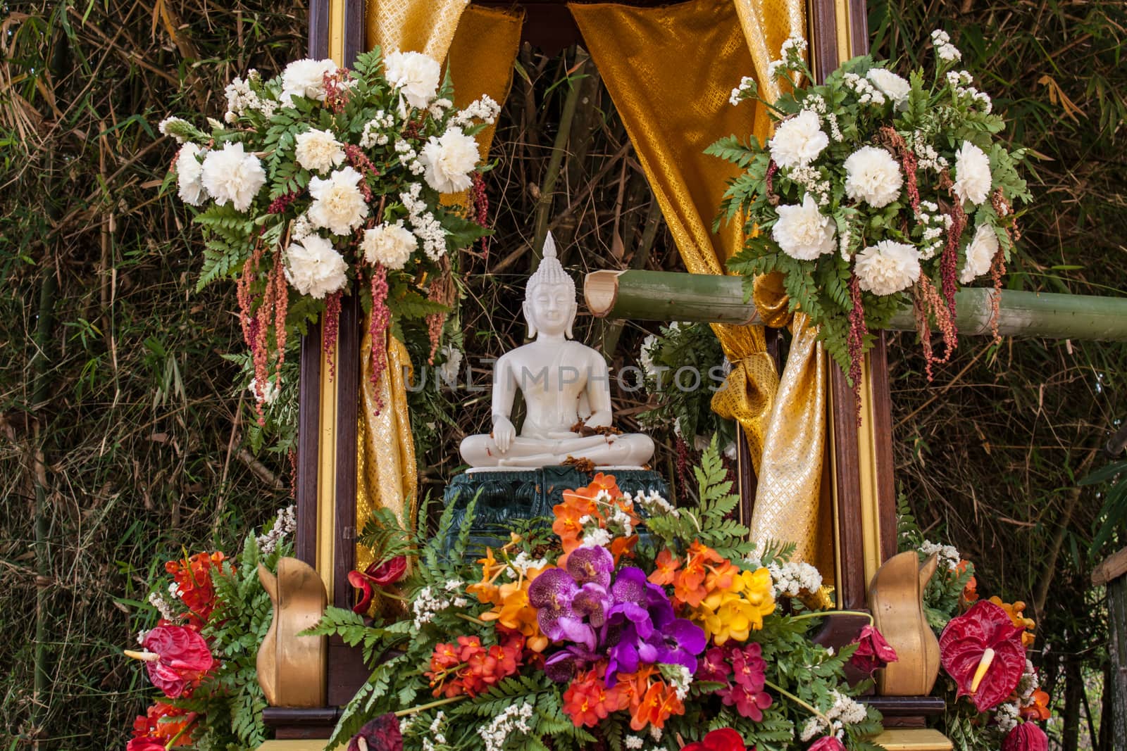 Buddha image and flowers in the annual Buddhist lent songkran festival