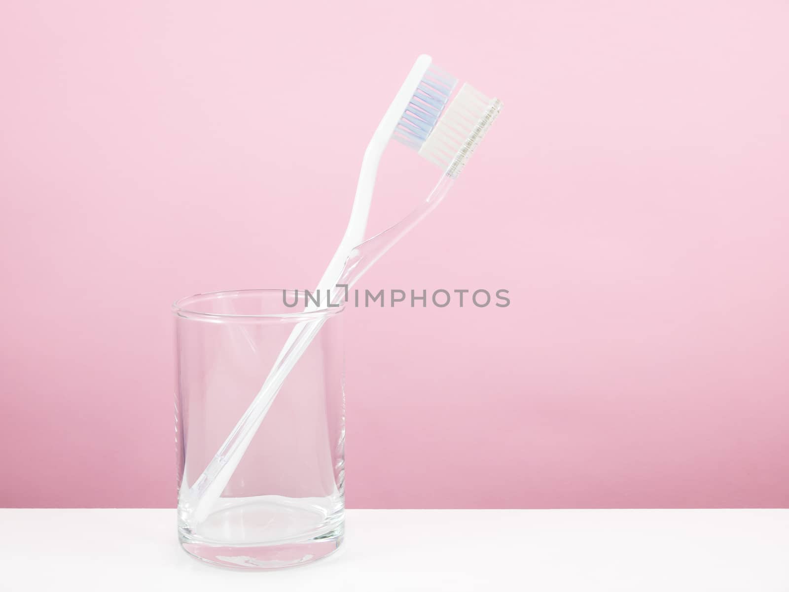 The white toothbrush with small glass by phasuthorn