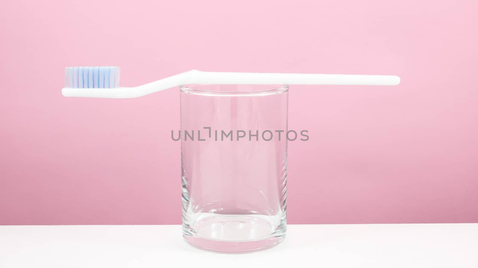 The white toothbrush with small glass by phasuthorn