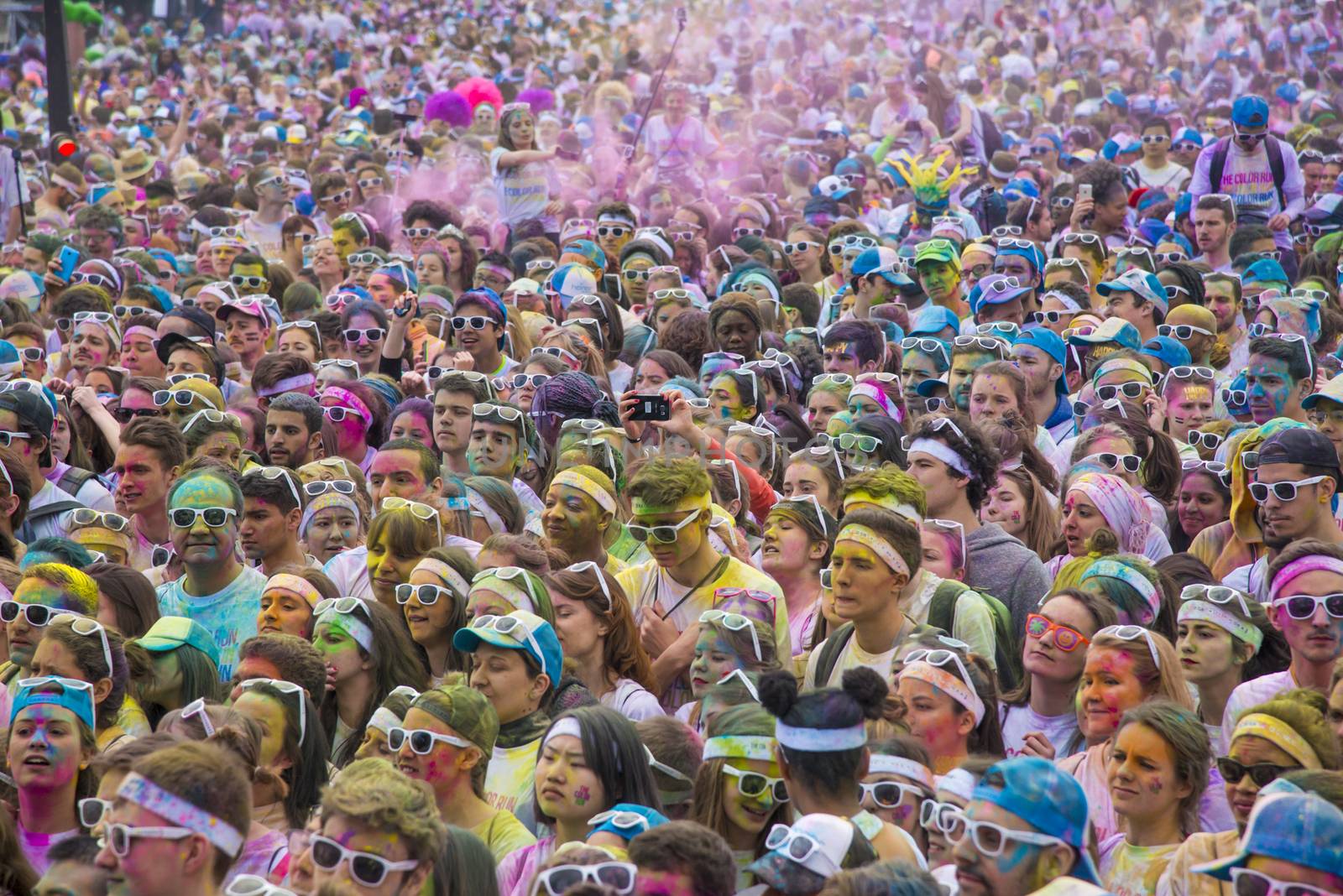 FRANCE, Paris : People participate in the Color Run 2016 in front of the Eiffel Tower in Paris on April 17, 2016. The Color Run is a five kilometres paint race without winners nor prizes, while runners are showered with colored powder at stations along the run. 