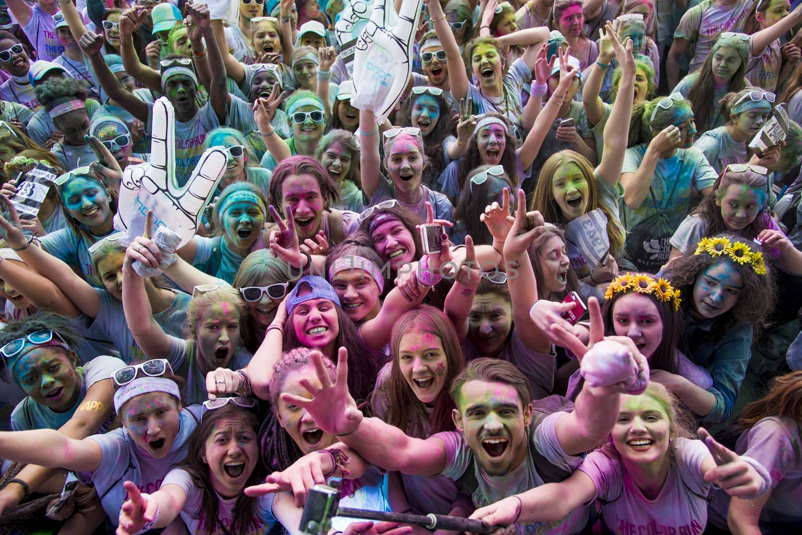 FRANCE, Paris : People participate in the Color Run 2016 in front of the Eiffel Tower in Paris on April 17, 2016. The Color Run is a five kilometres paint race without winners nor prizes, while runners are showered with colored powder at stations along the run. 