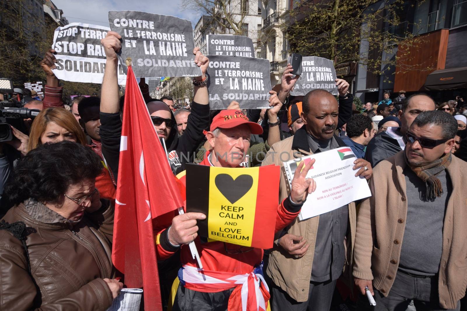 BELGIUM, Brussels : Protesters hold signs reading Against the terrorism and the terrorism and the hate, the solidarity or Stop terrorism, stop racism as they take part in the peaceful march #Tousensemble - #Sameneen against terrorism and hate in the city centre of Brussels on April 17, 2016.At least a thousand people paid a tribute to the victims of the terror attack of March 22 in the streets of Brussels during the peaceful march organised by citizens associations. 
