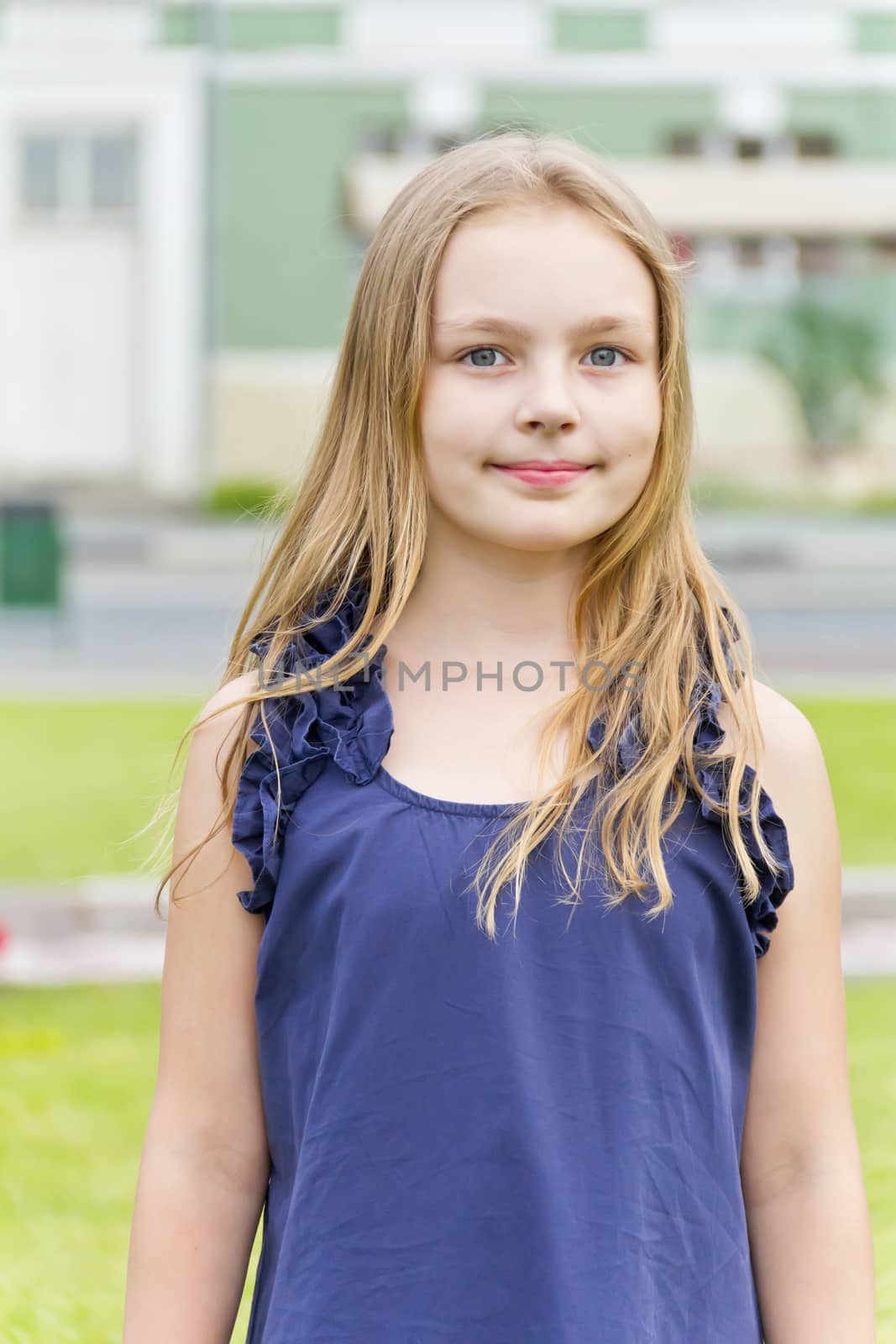 Caucasian cute girl with blond hair in blue dress