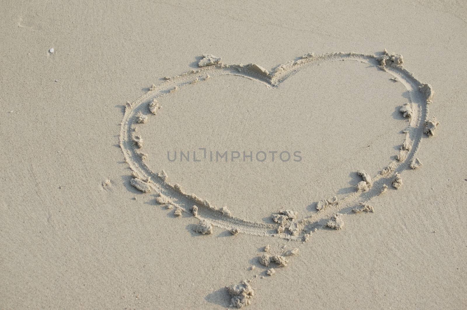 Heart sign of love on sand at beach use as background.